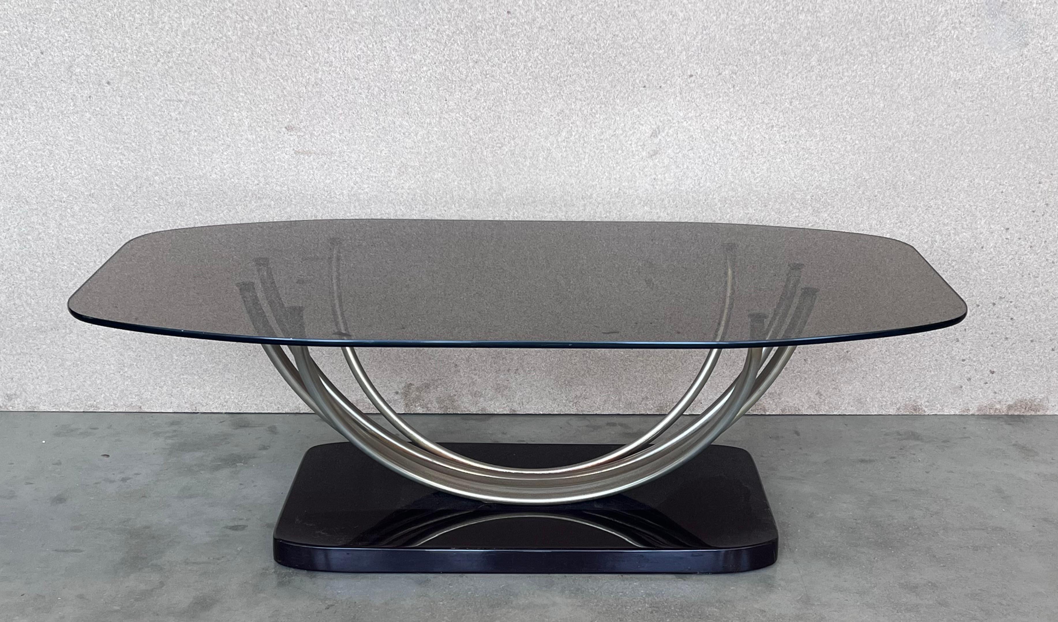 Amazing side or coffee table with curved chrome pedestal leg and the base of the table is made of ebonizd wood.
The smoked glass surface rests on the chrome pedestal


 The chrome and the wood have some sign of the time.