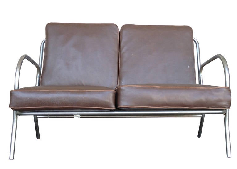 A rare 1930s chrome tubular loveseat. This sofa features a form and function design with the ability to fold up for easy storage and space saving in any room. In addition to folding up, it is also portable. The loveseat consists of a tubular chrome
