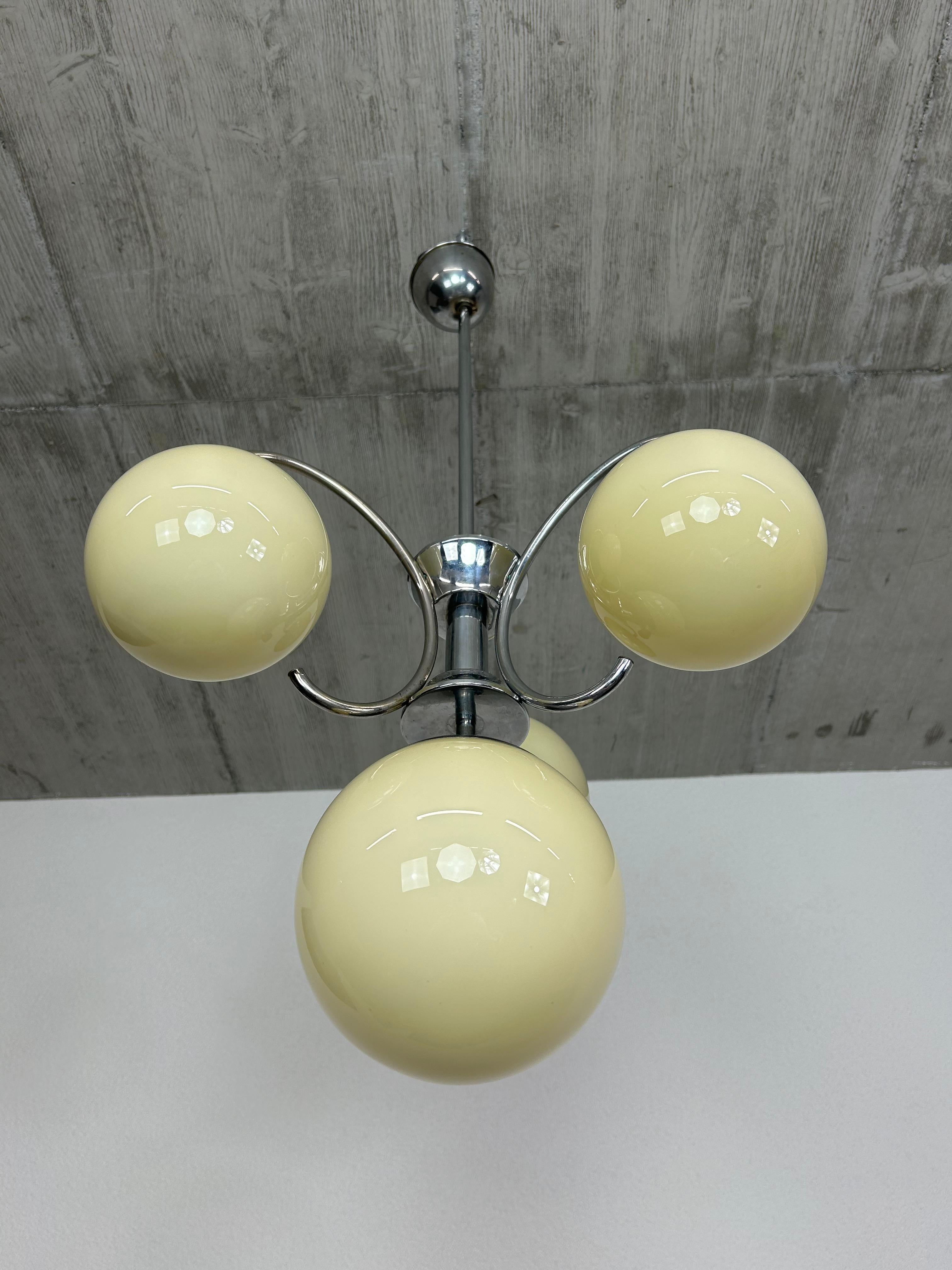 Lampada a sospensione Art déco cromata con paralumi a globo giallo chiaro in ottime condizioni originali.