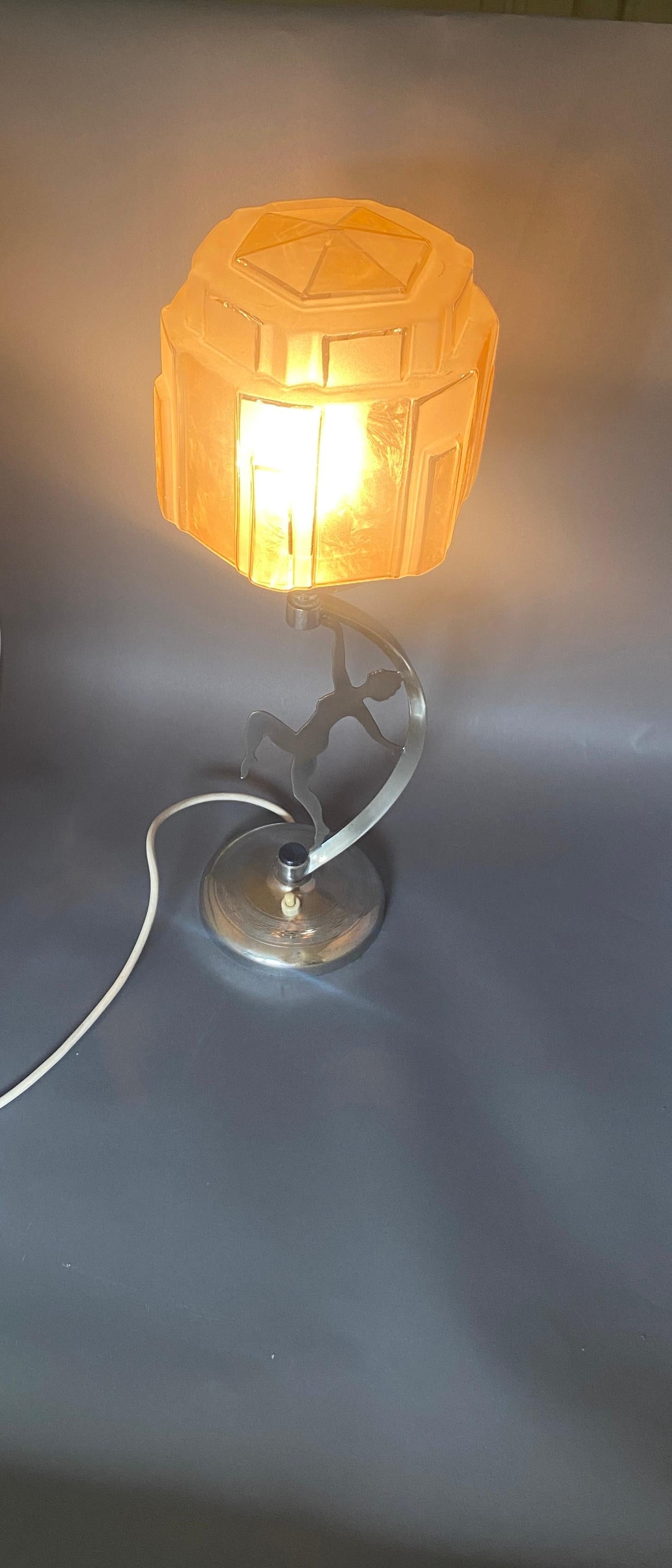 Lampe de dame art déco chromée avec abat-jour circa 1930
Silhouette de femme, avec détails gravés Costume de bain.
Support incurvé Ampoule et support d'abat-jour chromés, 
Base circulaire avec détails gravés, 
Globe Art déco de couleur pêche, de