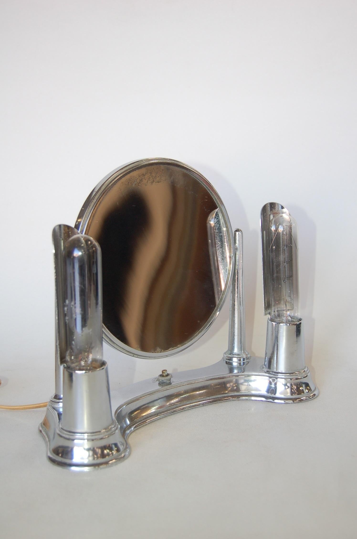 Art Deco chrome lightup vanity makeup magnifying mirror by Bel-Ayre. Takes two 400 watt bulbs. On and Off button.

Measures: 10