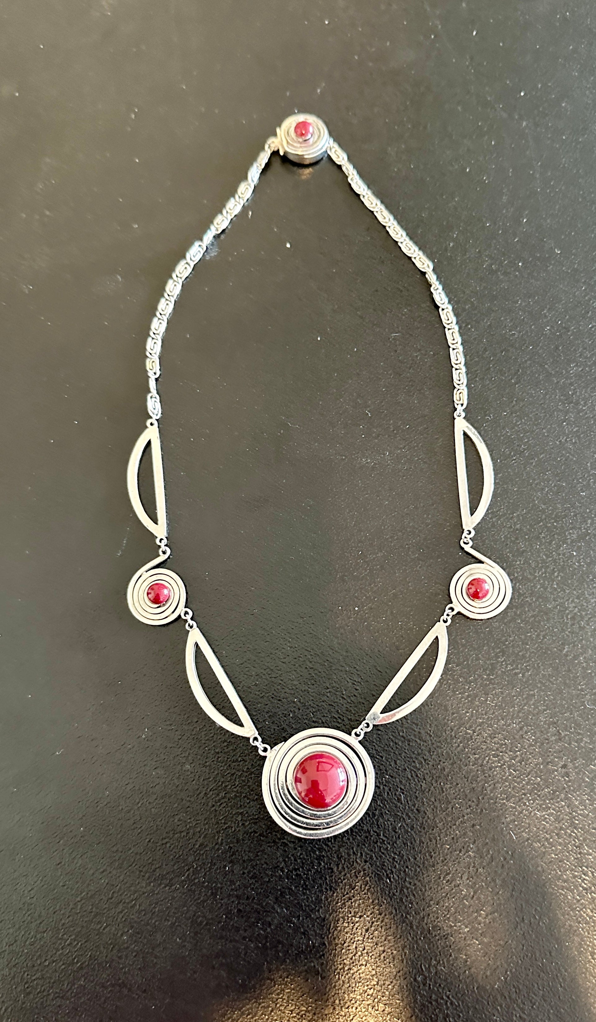 Indulge in a magnificent rare antique Art Deco Chrome Machine Age Necklace with fabulous geometric design and red Galalith adornments.  The necklace is in the style of Jakob Bengel but is not signed.  The necklace is the epitome of Art Deco jewelry