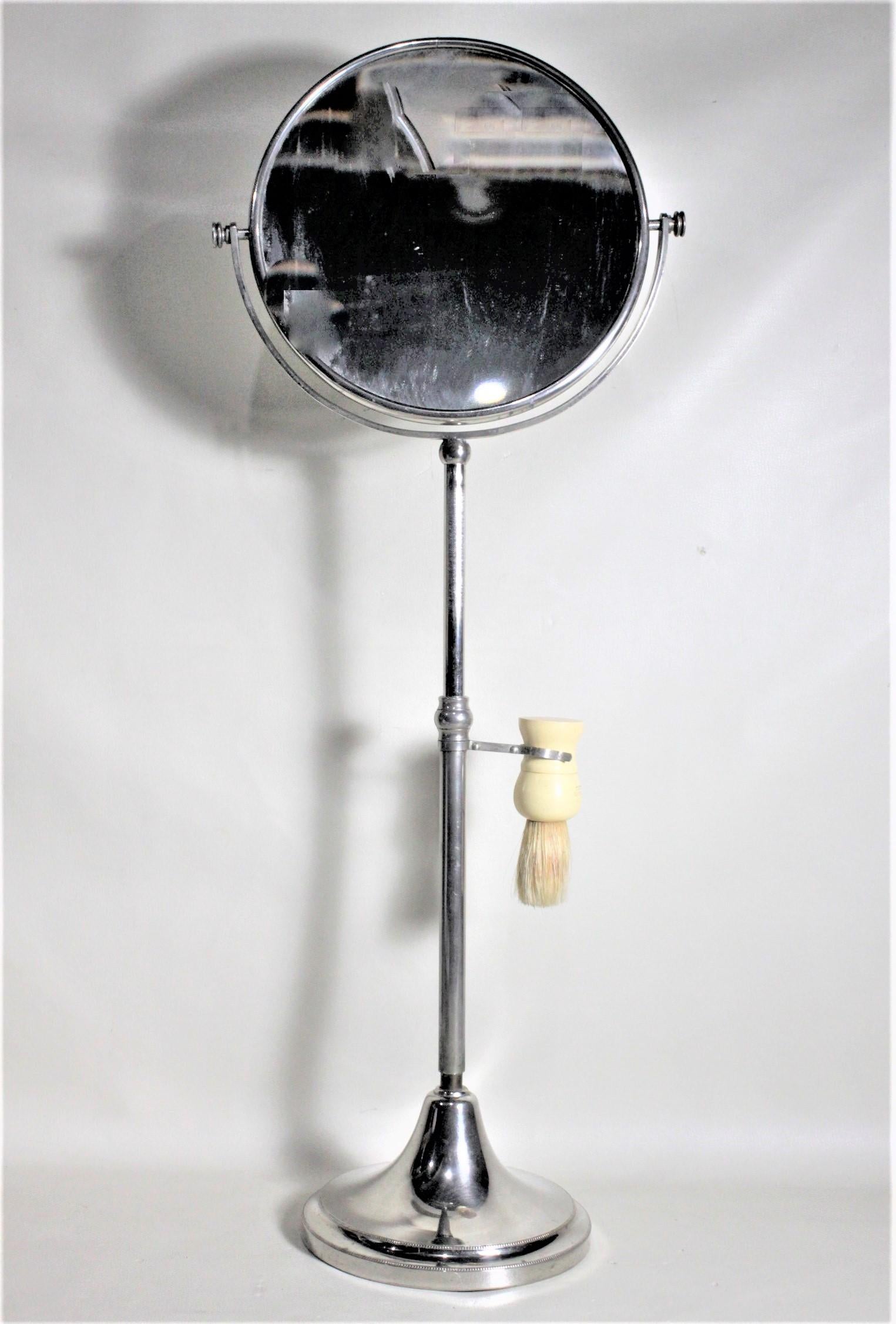 This chrome or nickel-plated pedestal shaving stand is unsigned, but presumed to have been made in the United States in the 1930s in the Art Deco style. The stand is well constructed and sturdy and has a screw down adjustment in the middle to allow