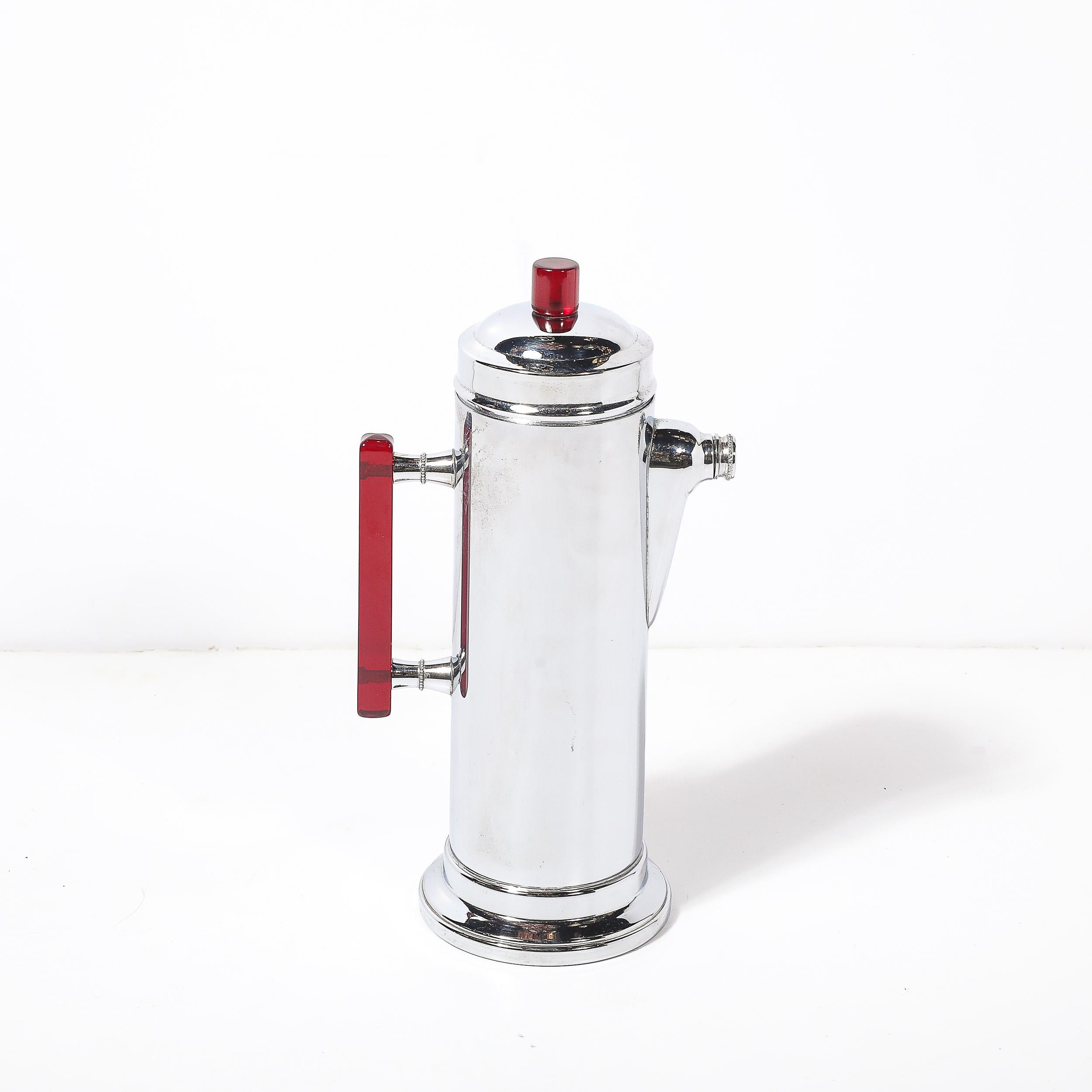 Dieser atemberaubende Art-Déco-Cocktailshaker, der um 1935 in Amerika hergestellt wurde, ist ein Beispiel für die elegante und moderne Ästhetik des Maschinenzeitalters. Mit seinem polierten Chromgehäuse und den auffälligen roten Bakelit-Akzenten