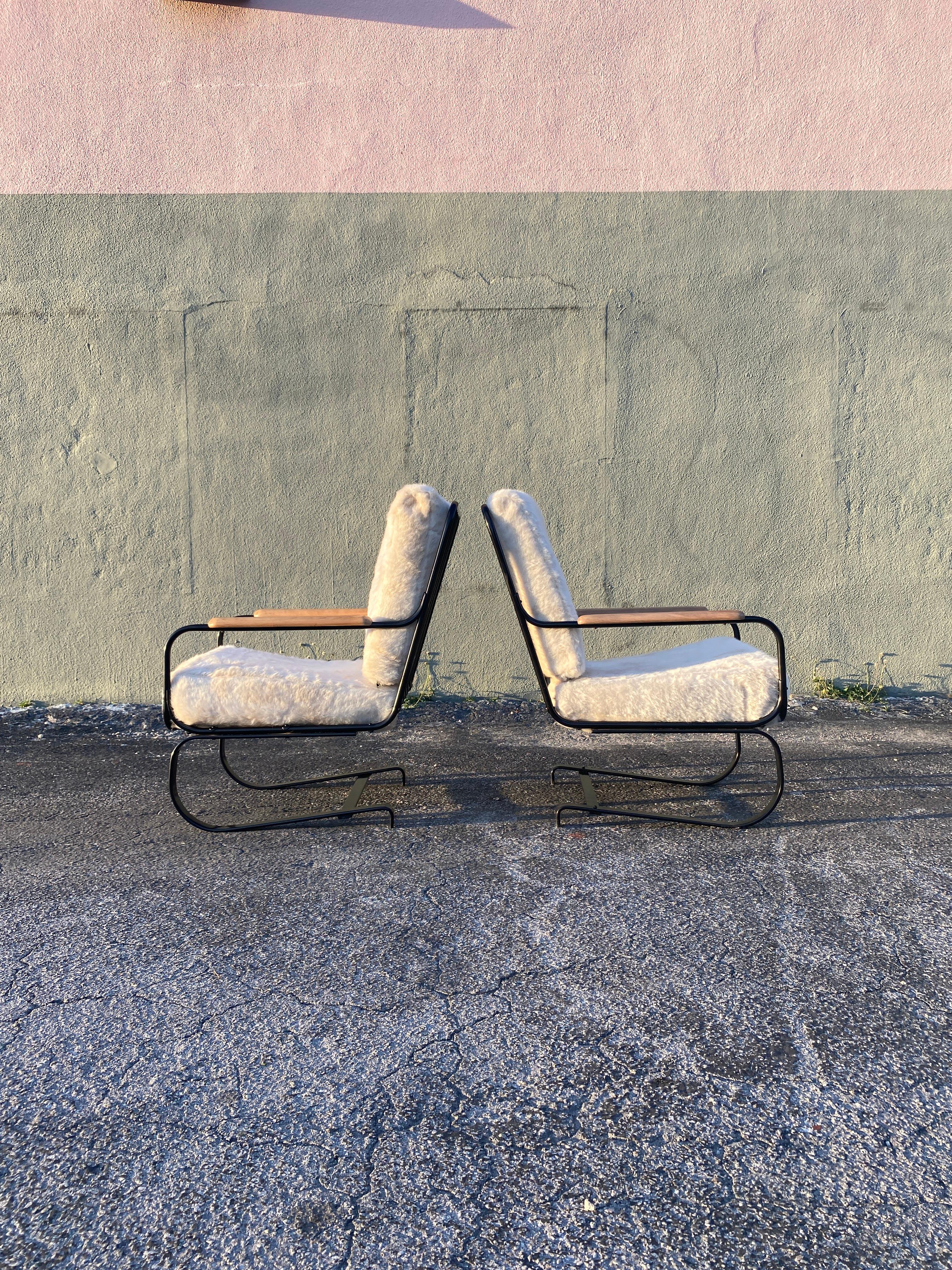 Art Deco rocker armchair designed by KEM Weber for Lloyd Manufacturing known simply as the “Springer Chair”. Chair sits on a thick steel flat bar and functions as a rocker. Recently upholstered in off white faux fur complementing its black frame and