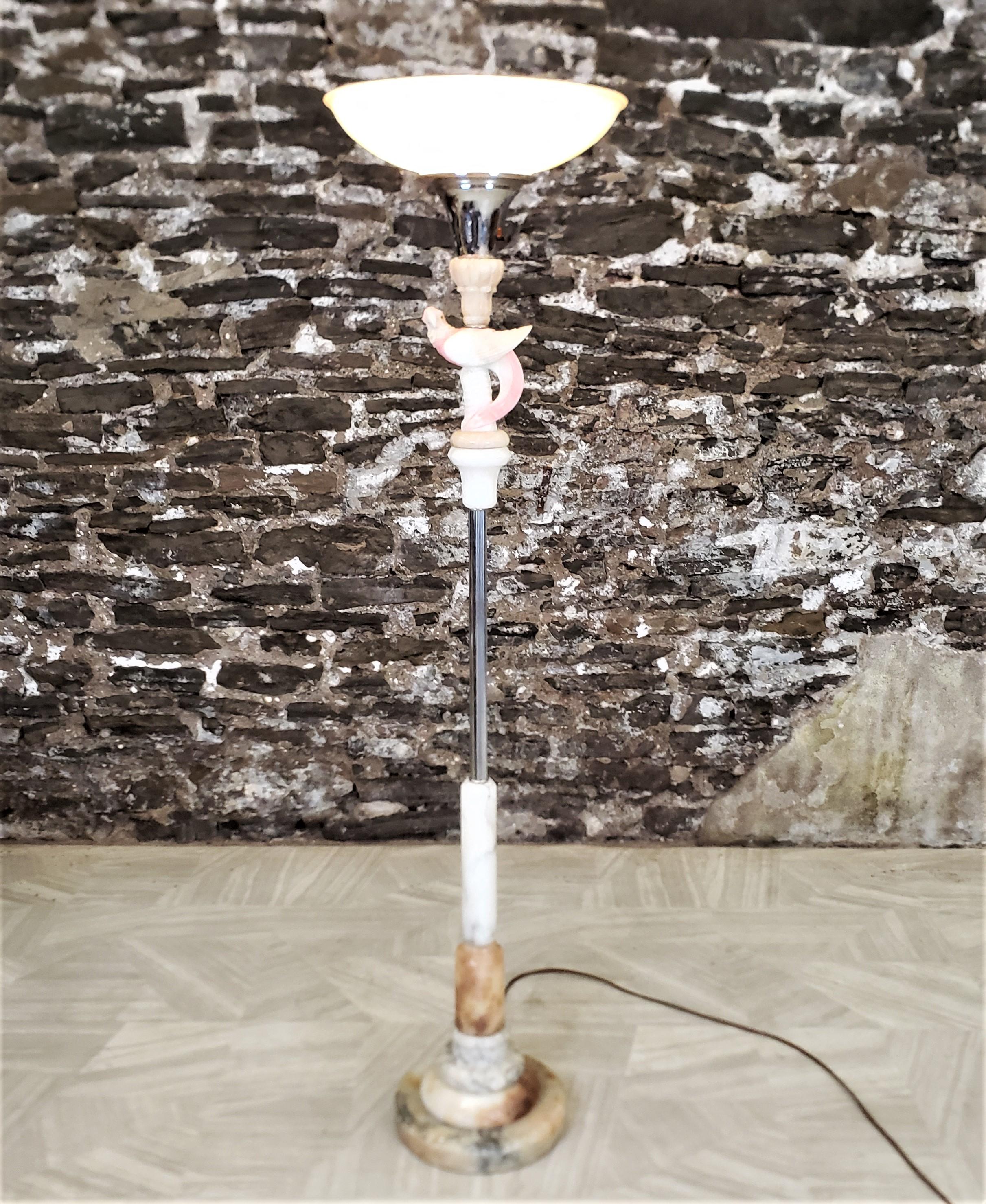 Ce lampadaire torchère antique n'est pas signé, mais on présume qu'il provient des États-Unis, qu'il date d'environ 1920 et qu'il a été fabriqué dans le style Art déco de l'époque. La lampe est composée d'une tige chromée avec un perroquet sculpté