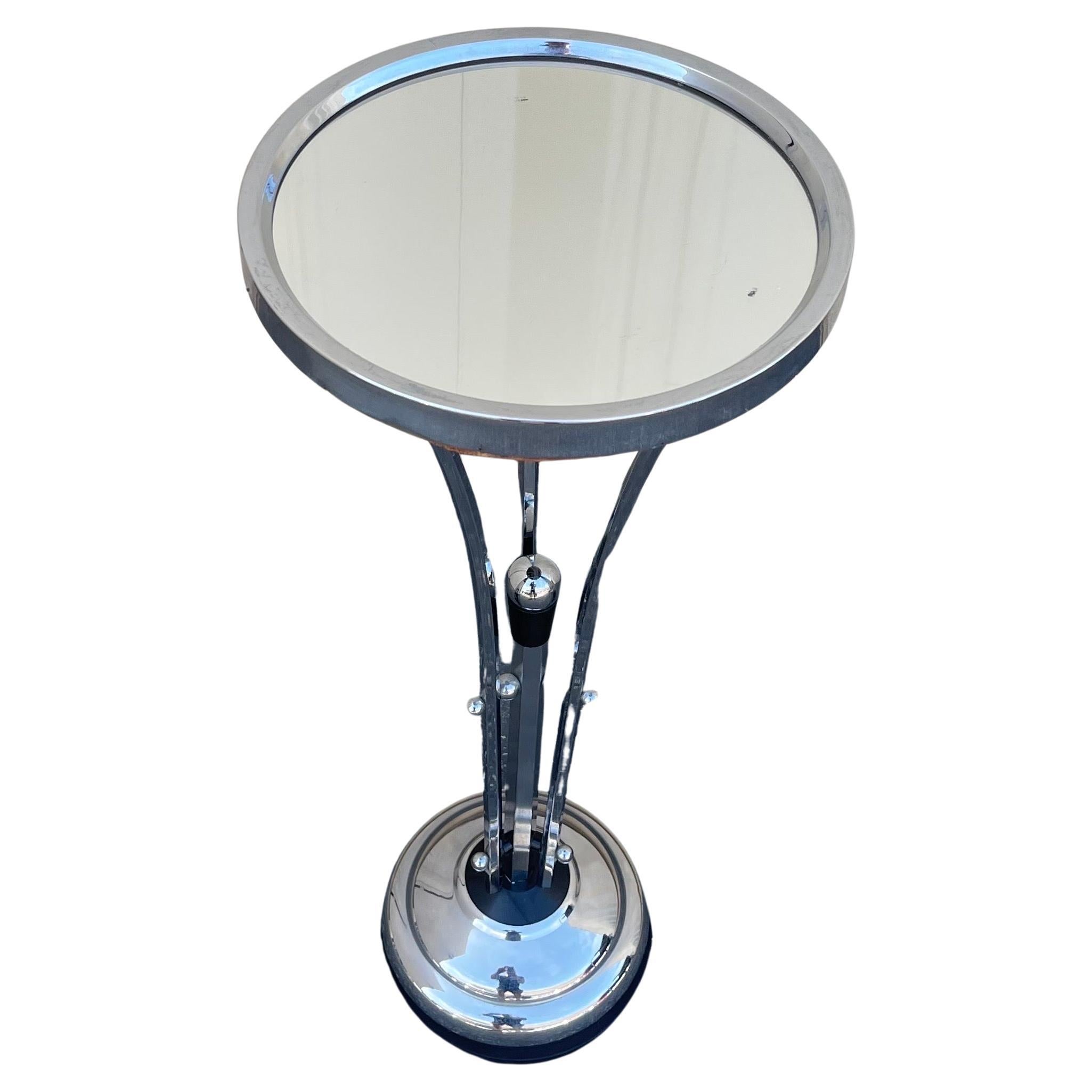 A very rare art deco chrome with mirror top martini / side table, circa 1940's.  The table has a great deco look with a black capped finial rising through the middle of the base.  The piece is in good vintage condition and measures 10.375