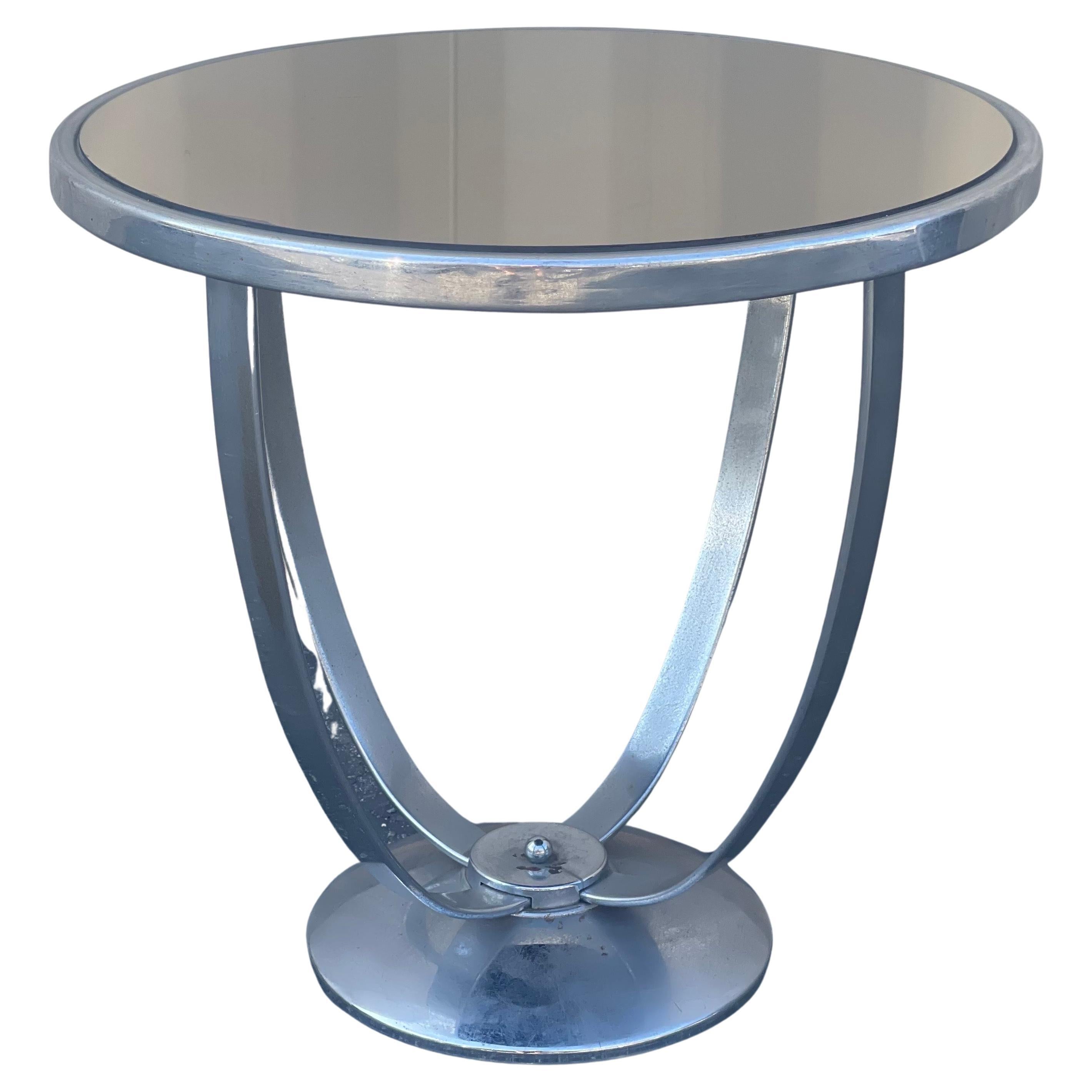 Très rare table d'appoint art déco / âge de la machine en chrome avec plateau en miroir par Wolfgang Hoffman pour Howell Co. vers les années 1930. Cette belle table au style gracieux est dotée de supports chromés plats et arqués et d'une base