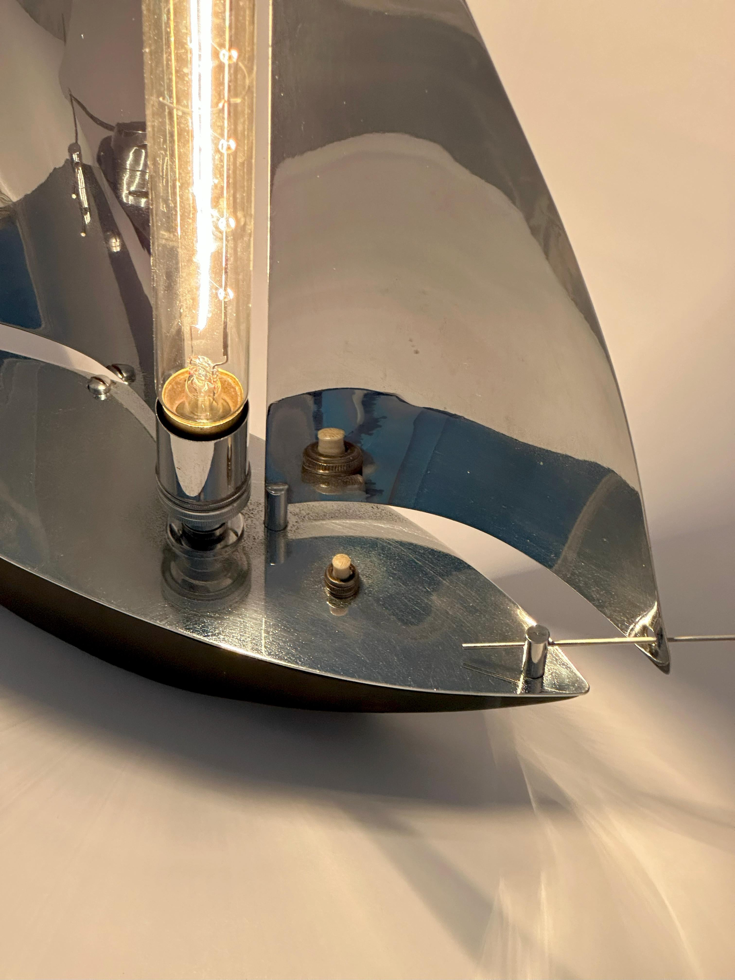 Un pezzo suggestivo dell'illuminazione Art Deco inglese, questa lampada da yacht cromata, realizzata intorno agli anni '30, cattura l'eleganza snella e l'ottimismo della sua epoca. La forma scultorea è quella di uno yacht stilizzato, con ampie vele