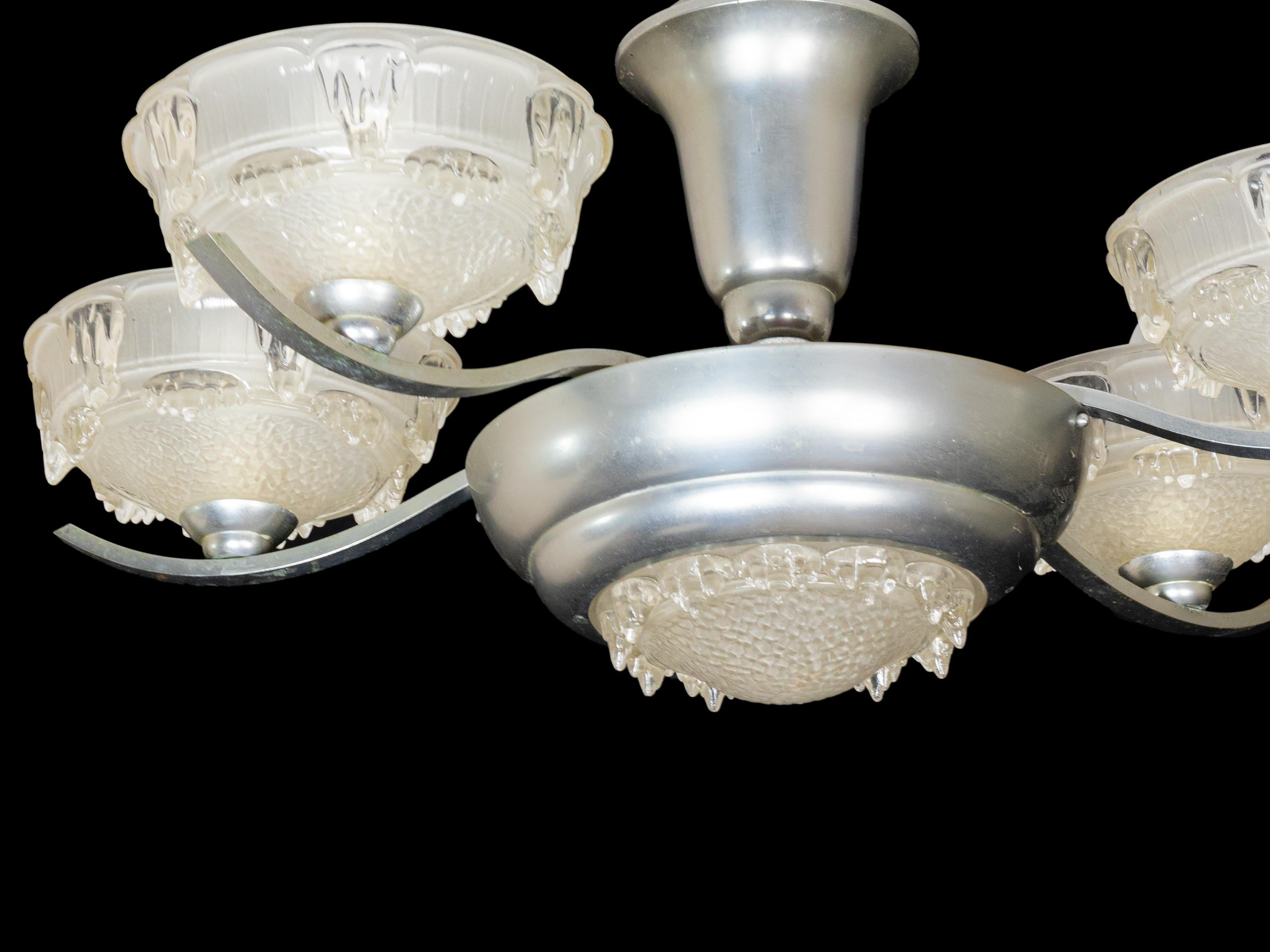 Esta lámpara de techo Art Déco cromada presenta cuatro brazos bellamente curvados adornados con pantallas de cristal esmerilado.
Esta lámpara colgante refleja a la perfección la elegante sofisticación de los años 30. Ideal para ambientes de estilo