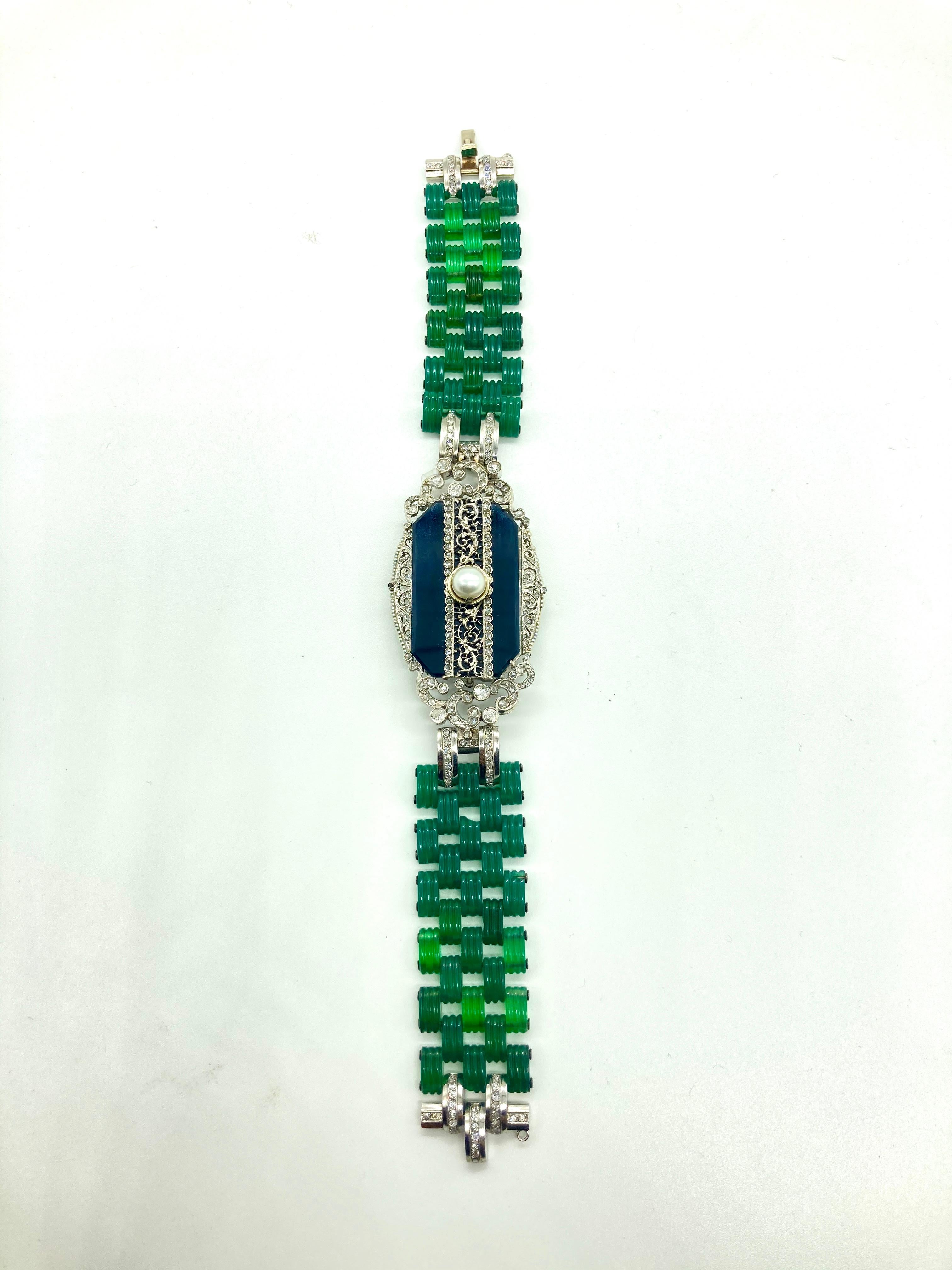 A beautiful Art Deco bracelet featuring fluted chrysoprase, onyx, pearl, and diamonds. Circa 1920.