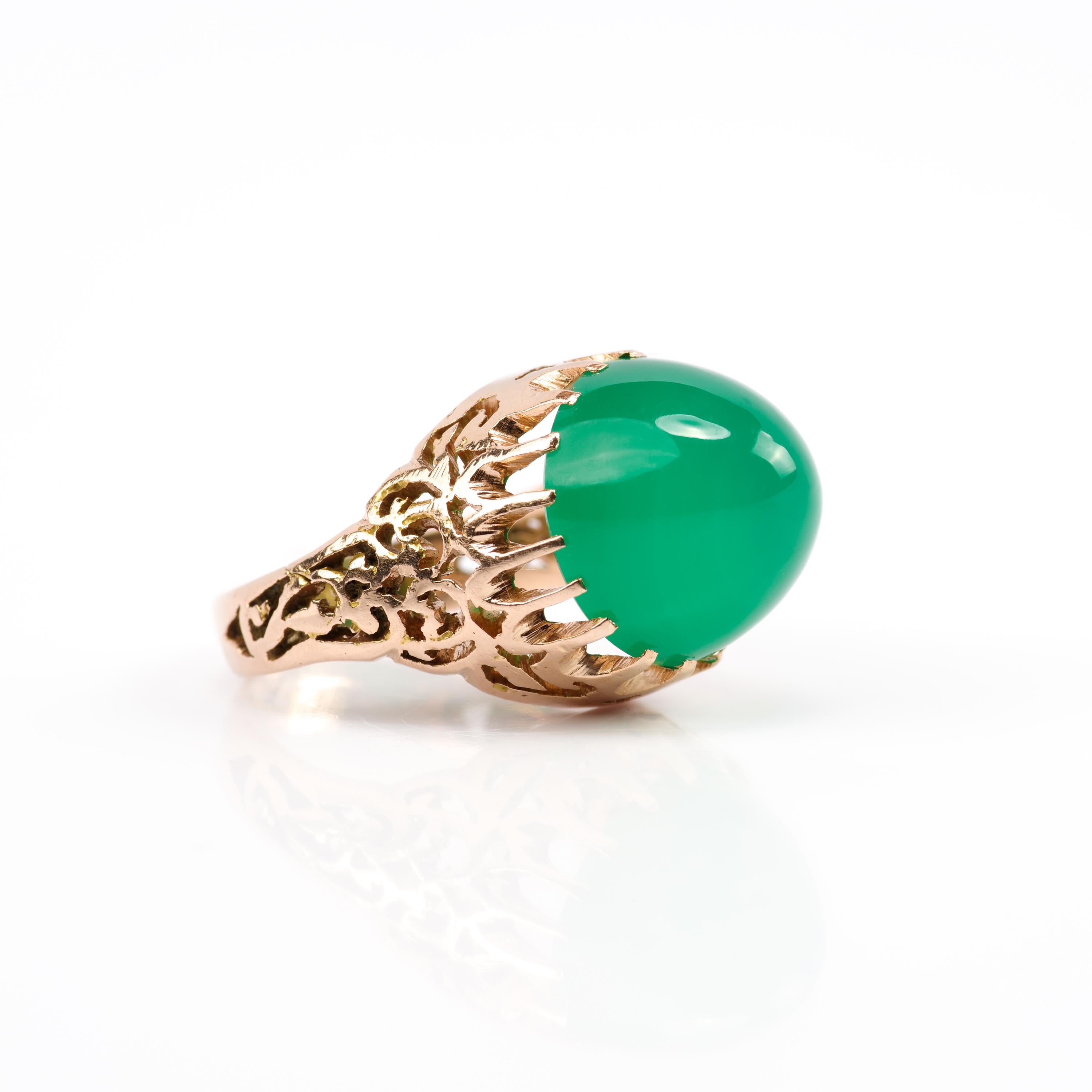 A vivid green translucent sugarloaf chrysoprase gem is held aloft by nineteen dutiful prongs in this dramatic and infinitely cool Art Deco ring from Egypt. Entirely hand-crafted in 14K rose gold —the perfect compliment to the flawlessly polished and