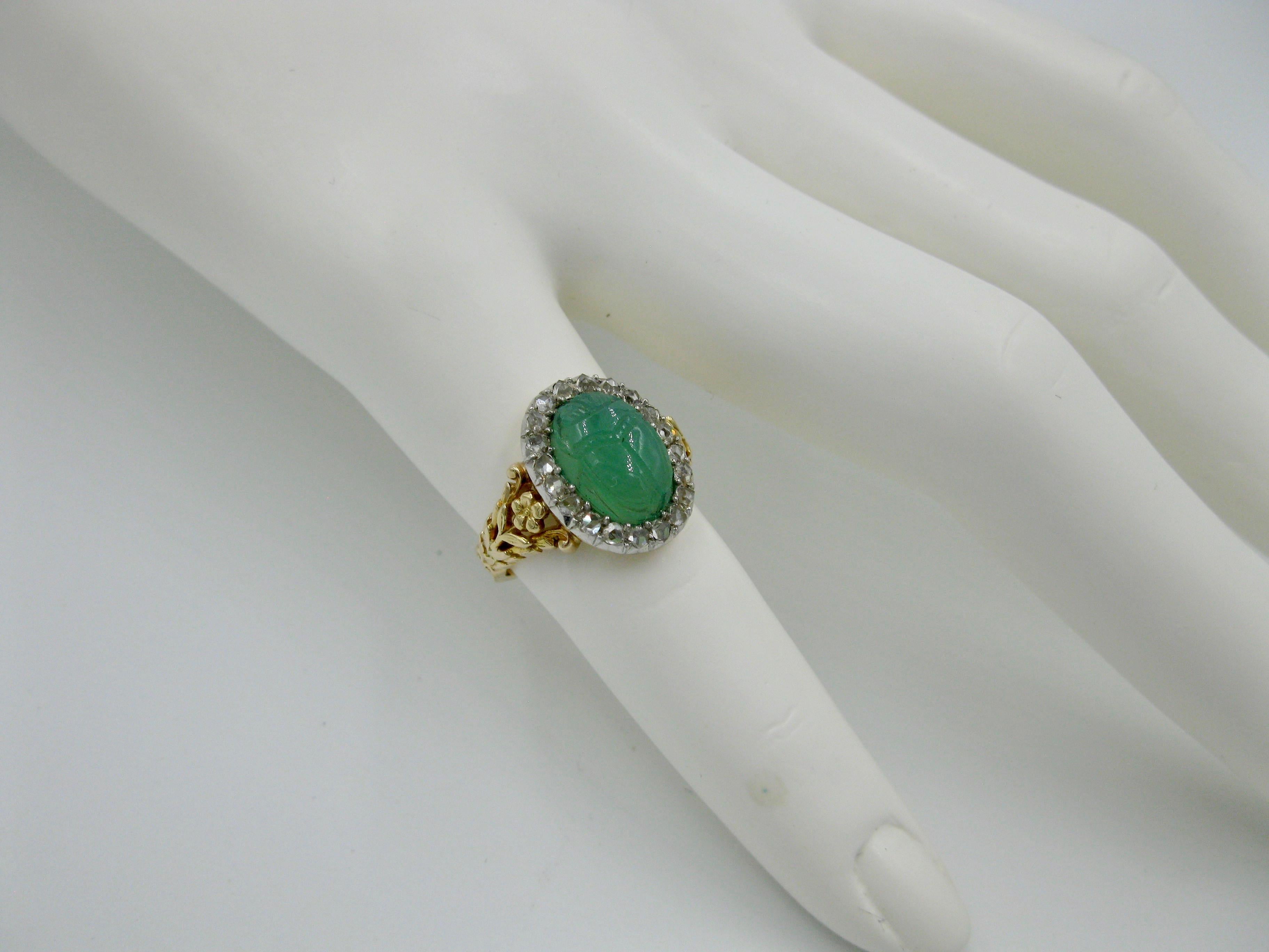 A museum quality Art Deco Egyptian Revival masterpiece.  The ring with a central Scarab carved in Green Chrysoprase of great beauty.  The Scarab is surrounded by a halo of sparkling Rose Cut Diamonds.  The jewels are set in a flower motif setting in