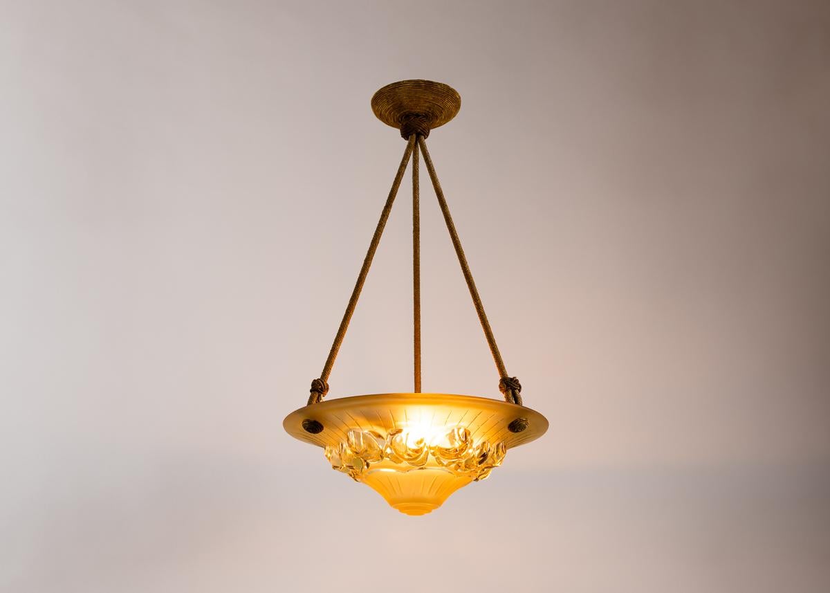 A charming petite Art Deco fixture with a charming shade of molded and colored glass and a well-balanced hanging apparatus.