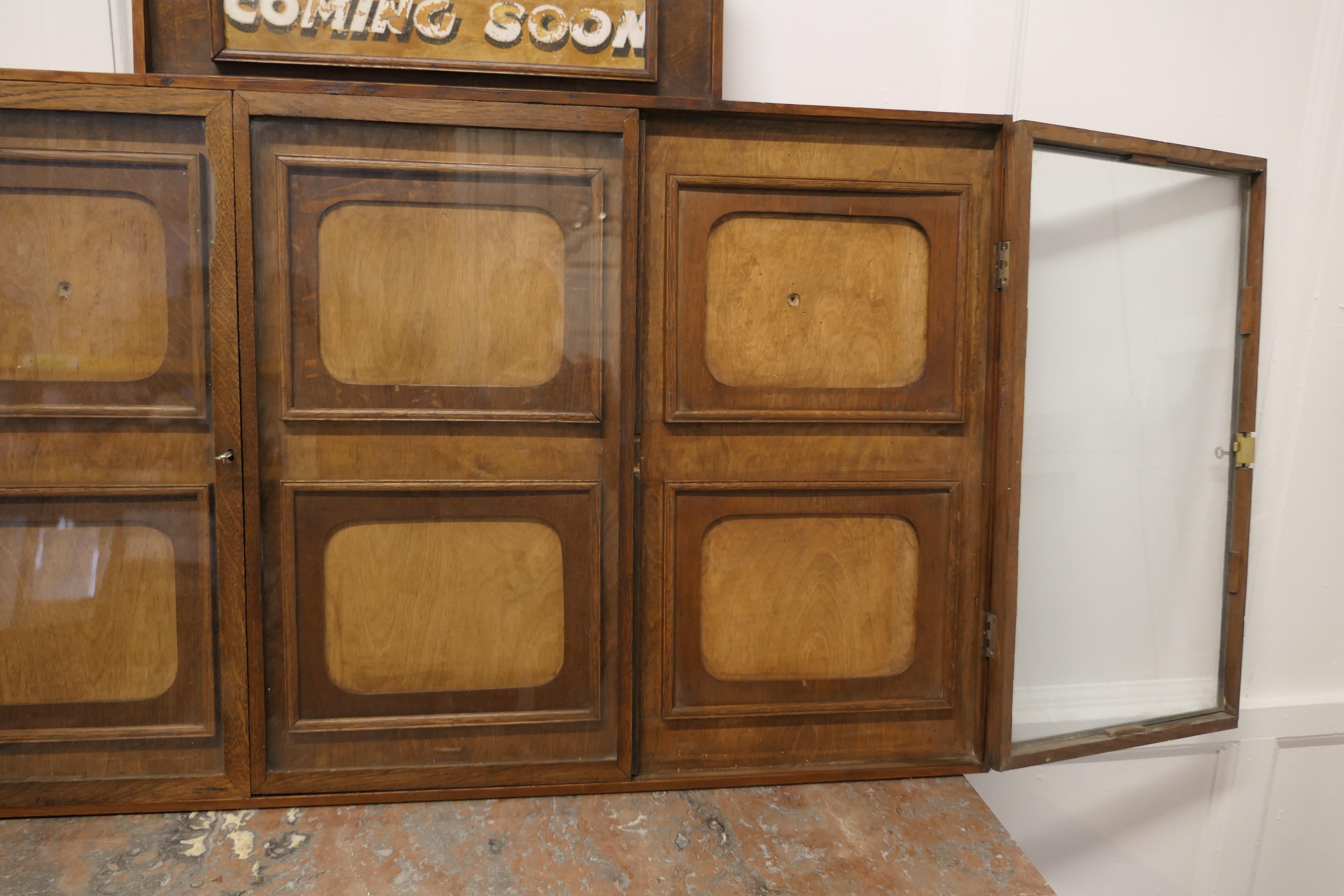 Art Deco cinema notice board, Odeon Advertising.

This is a shallow wall hanging cupboard, dating back to the early 20th Century, it is made in oak and designed to display 6 Film Posters
The Cabinet has 3 lockable doors, 2 hinged and the centre