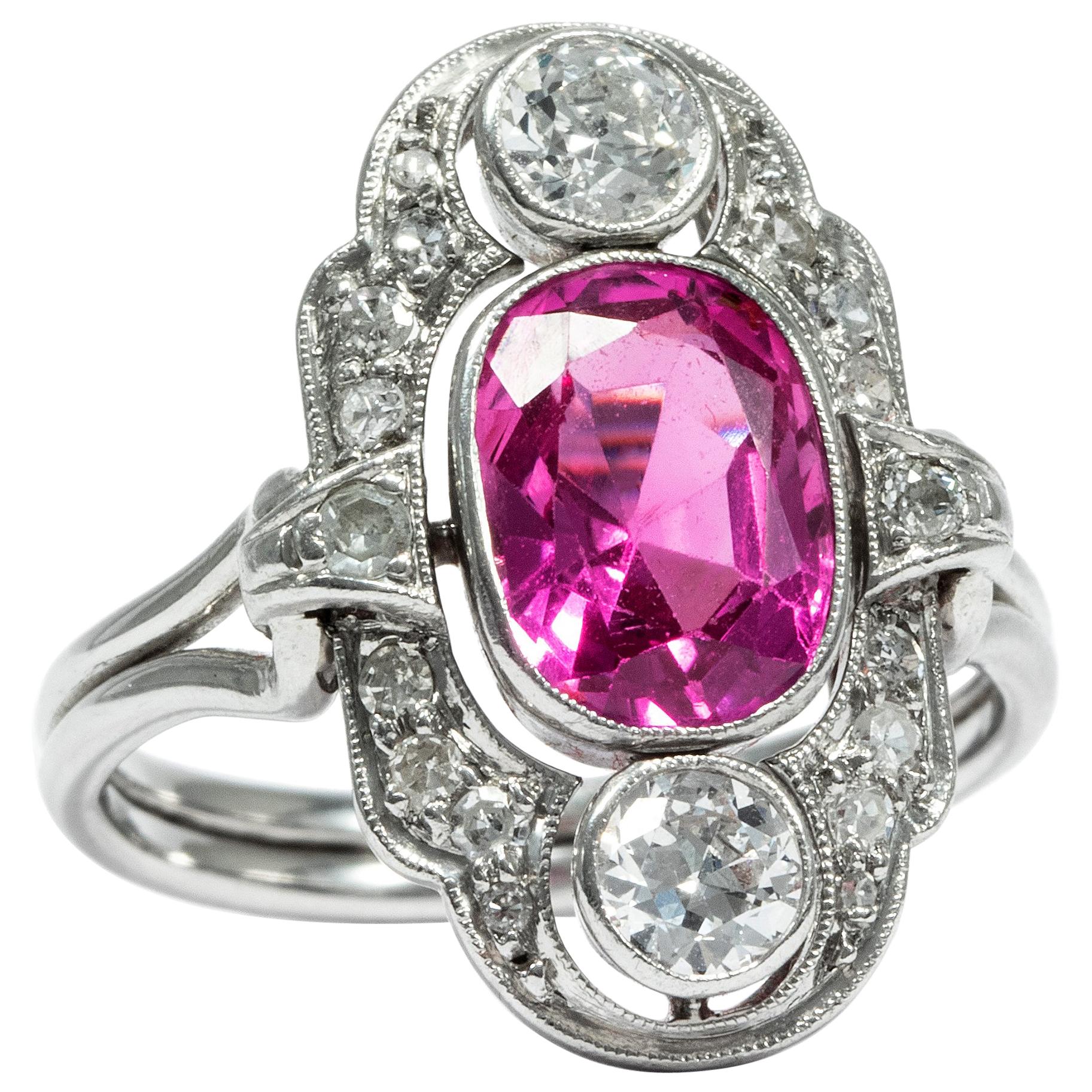 In the years around 1930, the Art Déco era favoured exquisite materials, geometric designs and white metals – and the ring at hand embodies this taste par excellence. A wonderful, natural sapphire in a vivid pink is the focal point of the design.