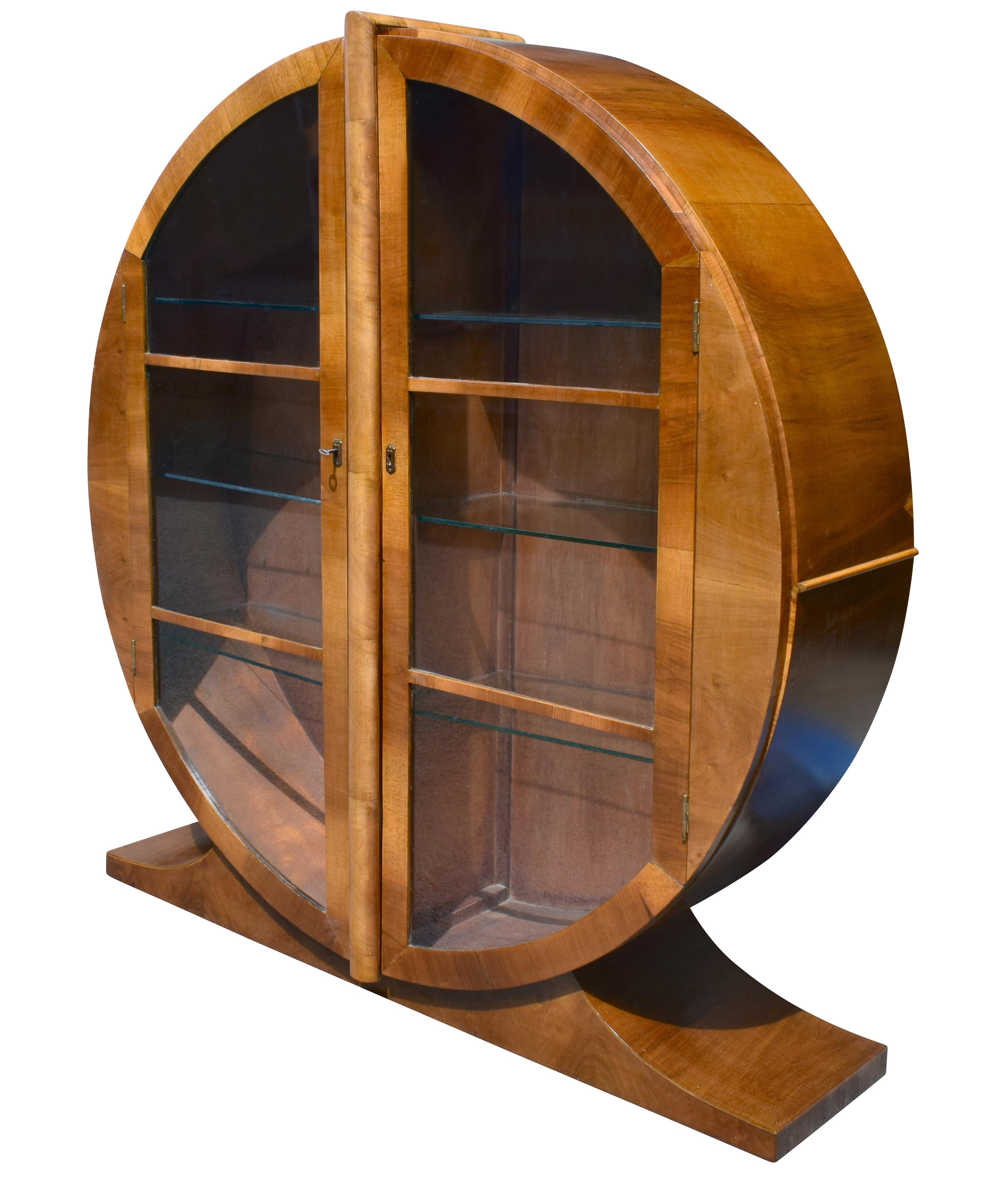 Every Art Deco interior should have one of these lovely 1930s English circular display cabinets. The high quality in beautiful walnut with ample internal storage makes this is a very functional piece. The two internal glass shelves are thick glass