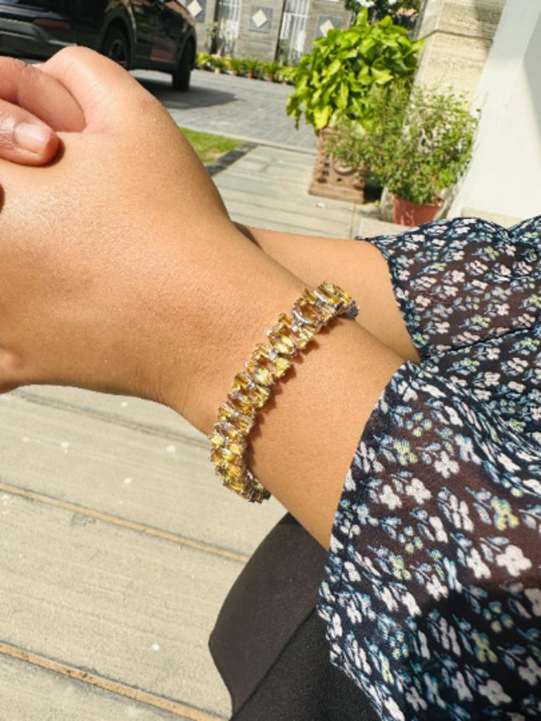 This radiant tennis bracelet is crafted in 925 sterling silver and adorned with vibrant citrine gemstones in marquise and baguette cuts. The warm golden hues of citrine create a luxurious, eye-catching design, perfect for adding a pop of color and