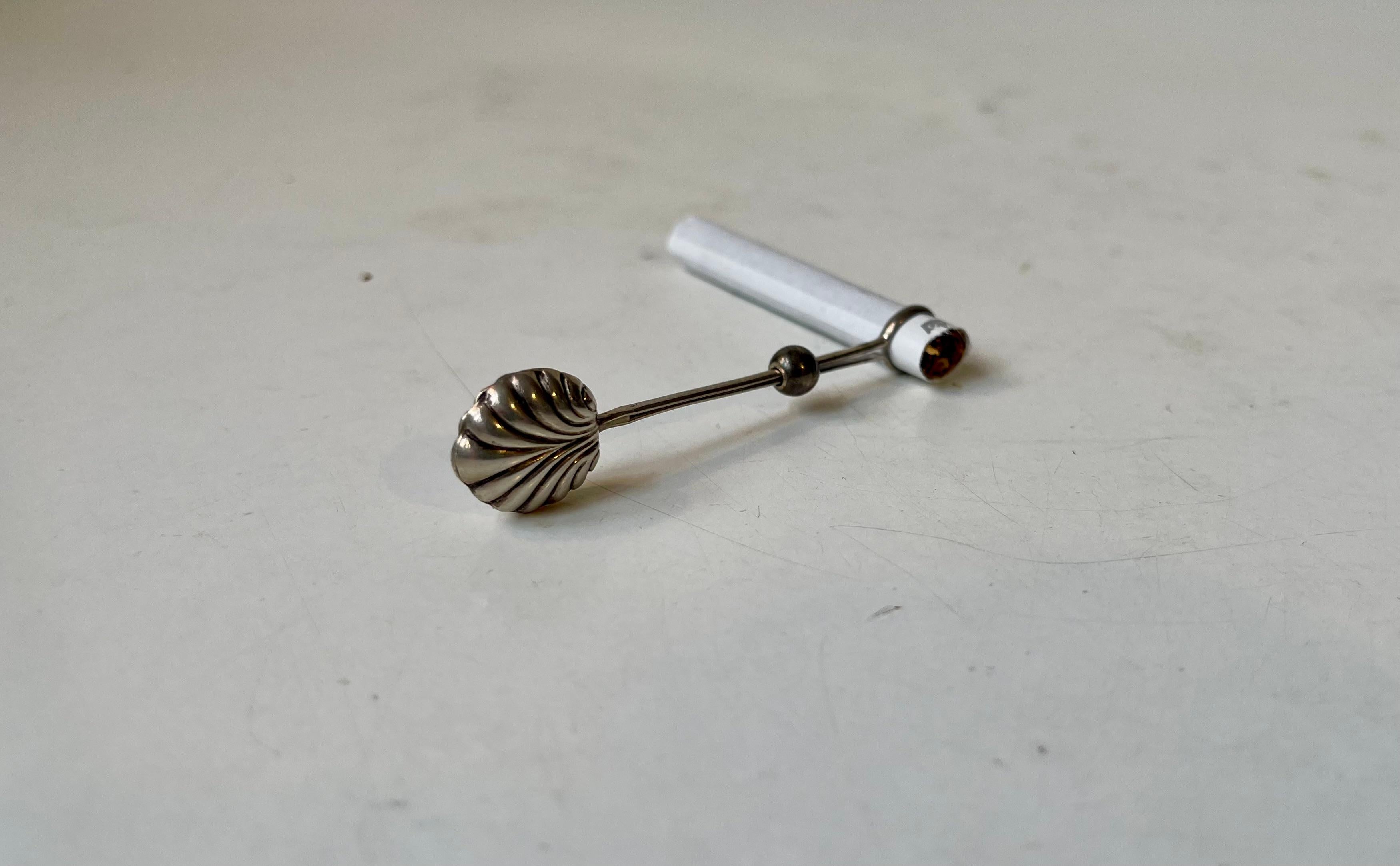 Elegant 1920s ladies cigarette holder in 830/1000 silver. It features an Art Deco stylized clam shell to its top and a tightening ball to keep in place the cigarette. Unidentified Danish silversmith in the style of Hans Hansen. Marked 830 and has