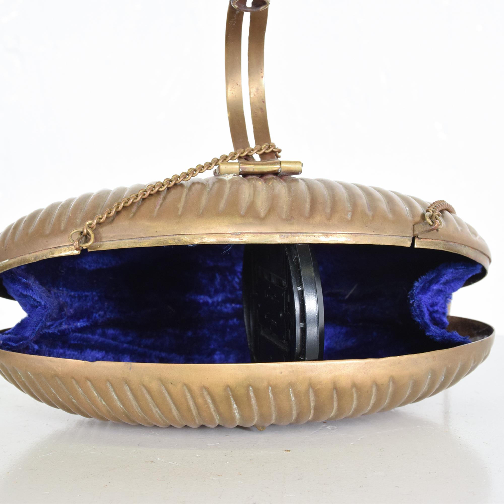 AMBIANIC presents
Art Deco Clamshell brass evening bag purse with gold shoulder chain + lovely velvet purple lining, circa 1940s
No maker label present. In the style of Judith Leiber.
4.5 L x 7 W x 2 D inches has long shoulder chain or hand carry