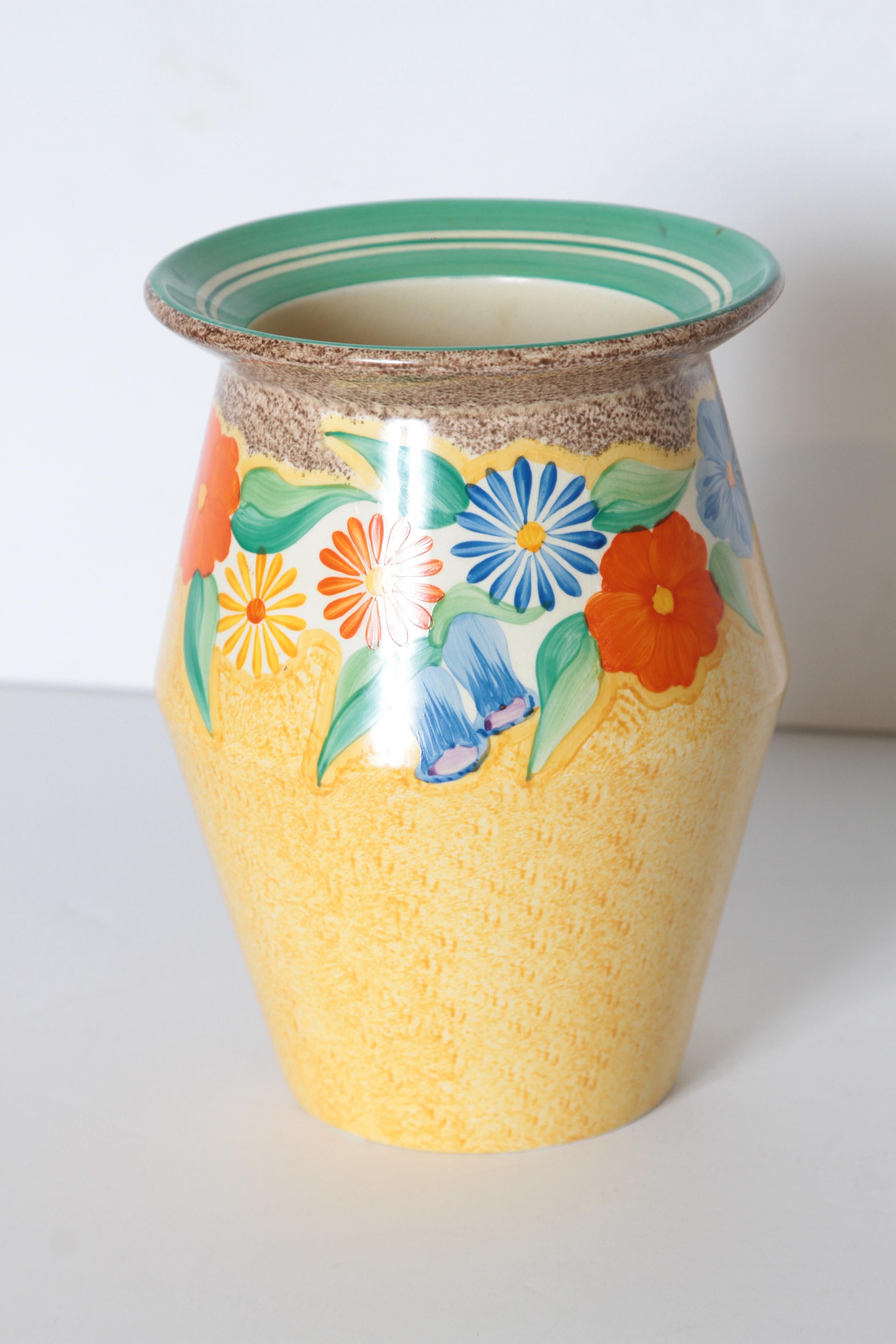 Art Deco Clarice Cliff bizarre vase, hand painted, Newport Pottery, England

Uncommon flared form and pattern. Almost a sponge - ware look to the yellow.
Top-banded multi-floral pattern with striped flared rim.
Good vivid colors; relatively