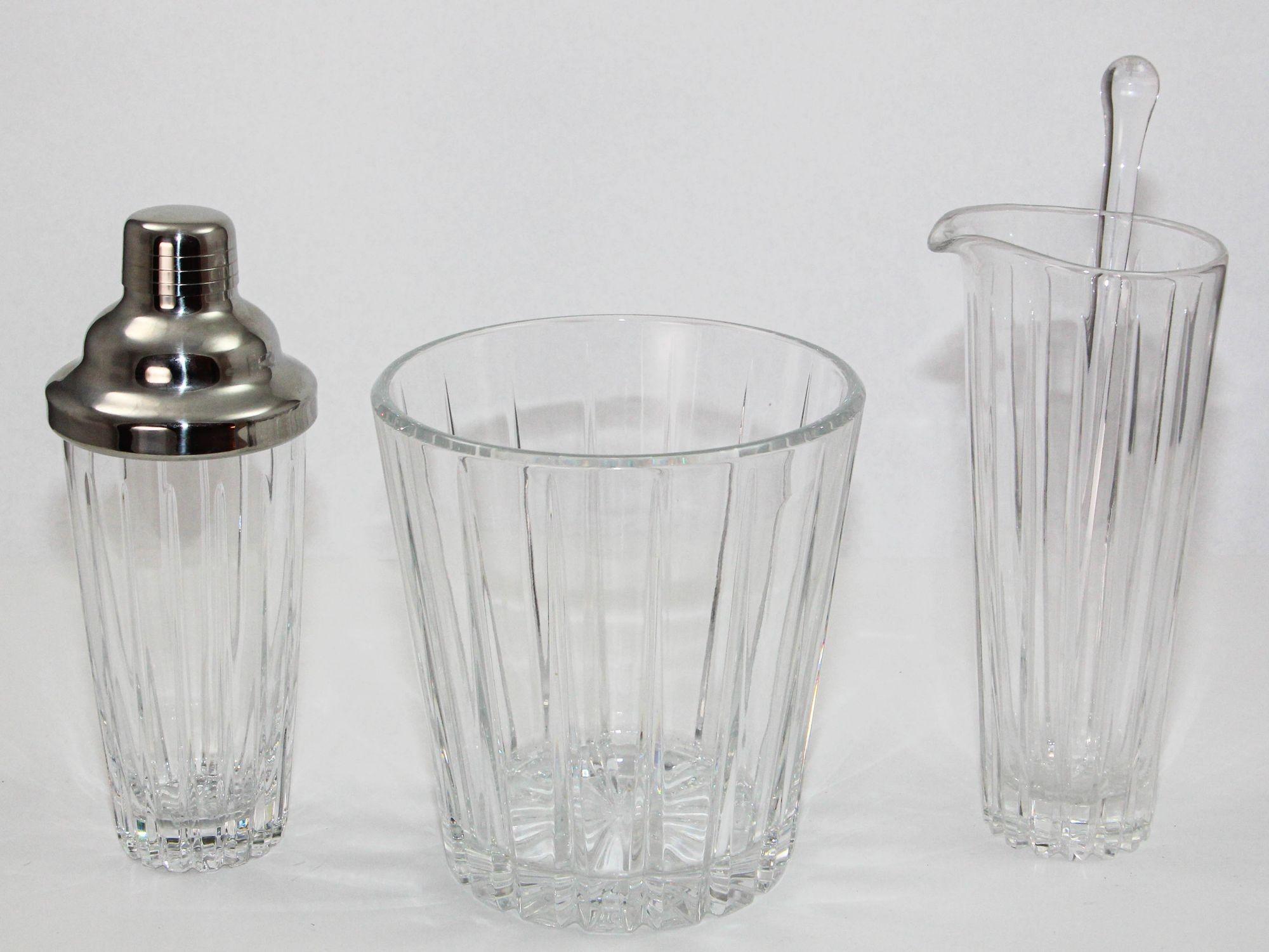 This Art Deco-inspired crystal cocktail set exudes elegance and contemporary flair with its vertical cut lines that impart a dazzling finish. Meticulously hand-cut and polished, the set includes a crystal cocktail shaker, ice bucket, and