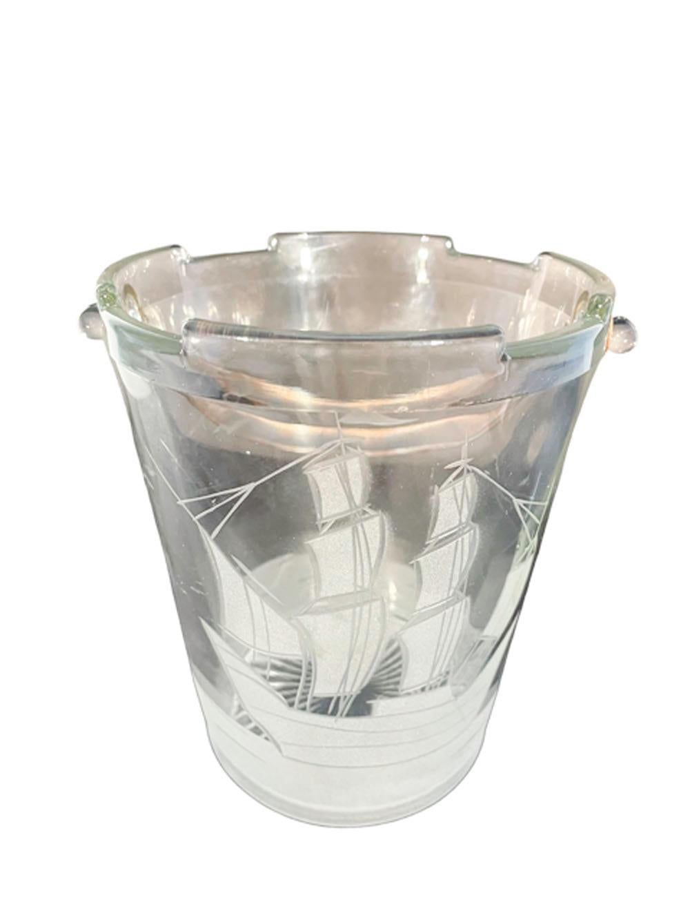 Clear glass Art Deco ice bucket of pail form with a starburst molded base and shaped rim with hammered metal handle, and with a sailing ship etched on the front with the water extending around the base and birds in flight to the back.