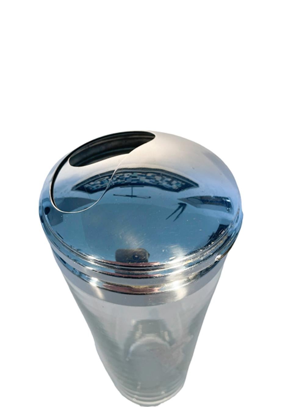 Clear glass cocktail shaker with a silver overlay golfer, set on a polished foot and capped with a two-part 'turn to open' lid, patented in 1932. The outer lid turns over the inner lid, when open cocktail ingredients can be placed directly through