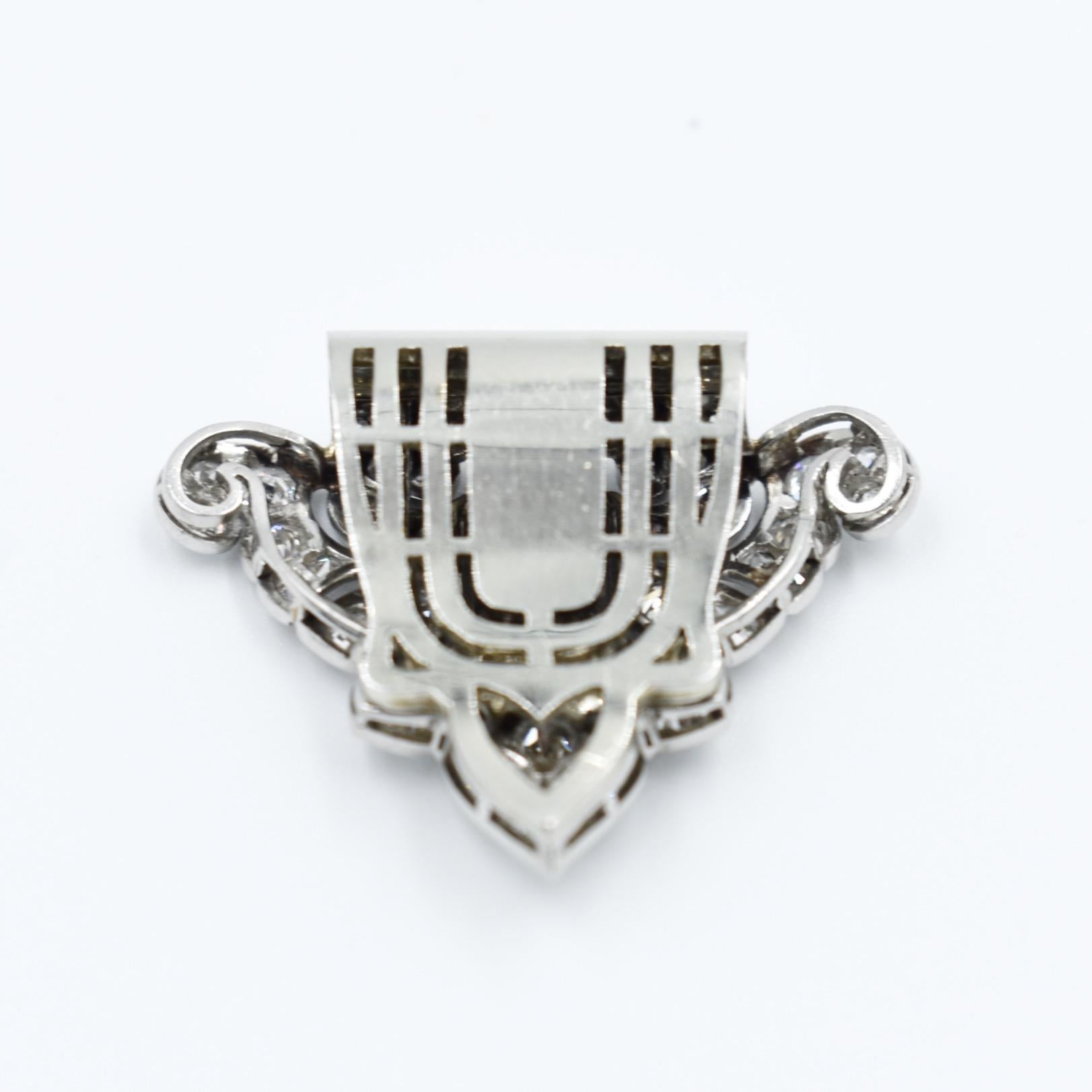 This is a stunning Art Deco clip from the 1920s, made of 18-carat gold and platinum, set with diamonds of various sizes, including baguette and half-cut diamonds, totaling approximately 3 carats. The clip features typical geometric designs of the
