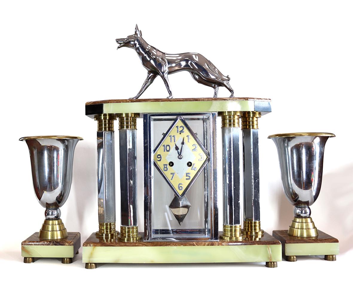 A very Stylish Onyx and Chrome Clock and Garniture is the epitome of Art Deco. This  mantel clock, with an unusual pendulum, has an eight day Pendule de Paris movement striking on a bell. The case and flanking vases are made of a striking