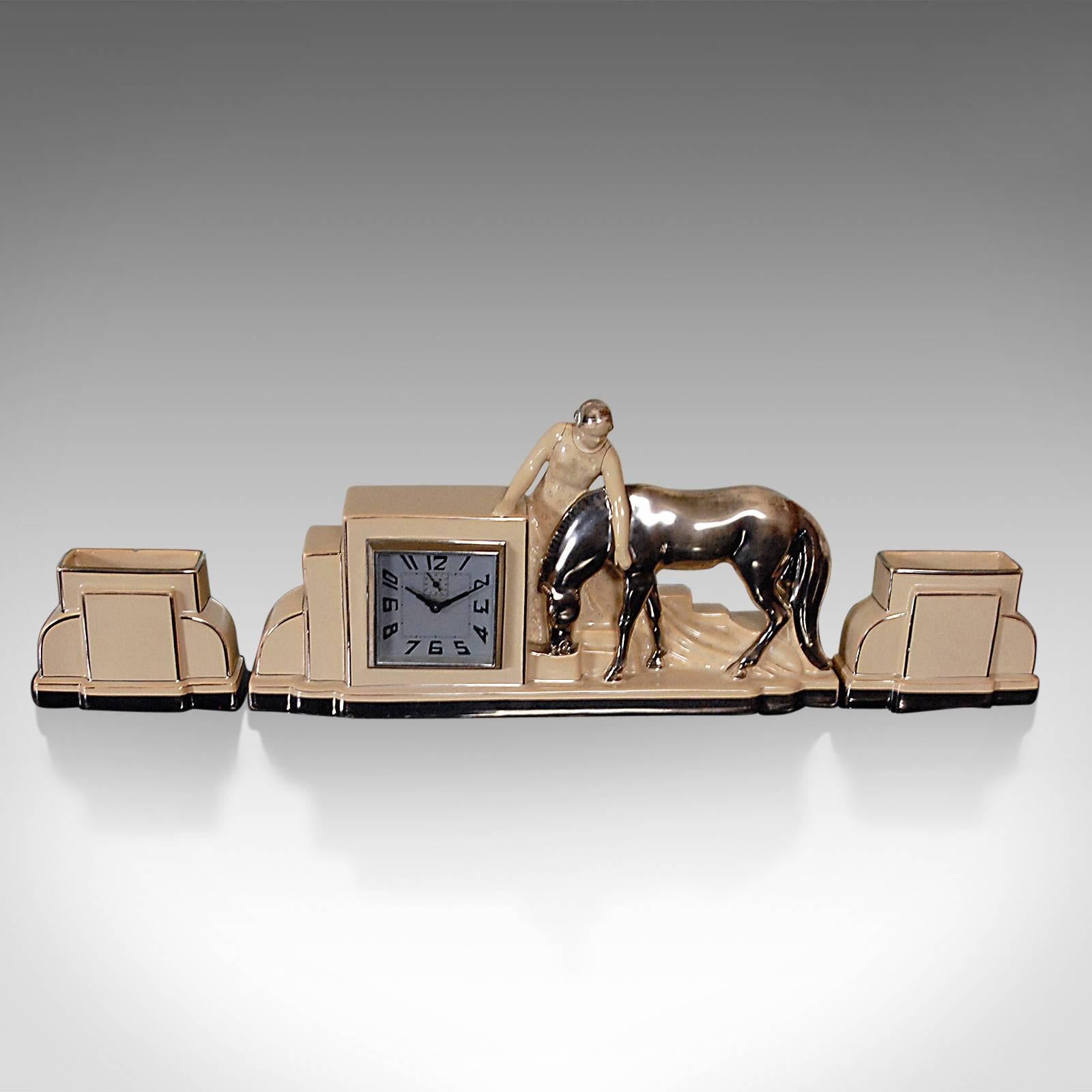 Art Deco at its finest from renowned French maker ODYV, this is a working clock featuring alarm function.

Displaying Classic deco form in an equine scene; a lady in typical flowing robe strokes a thoroughbred foal drinking from a