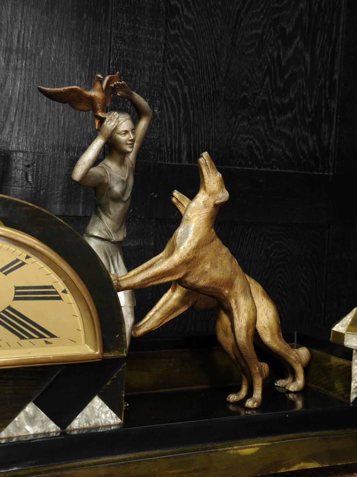 A stunning and rare clock by the well known sculptor Pierre Sega, circa 1925. It features a charming scene of a girl holding a bird aloft to save it from her two large and playful dogs. Beautifully modelled in colored and patinated white metal. The