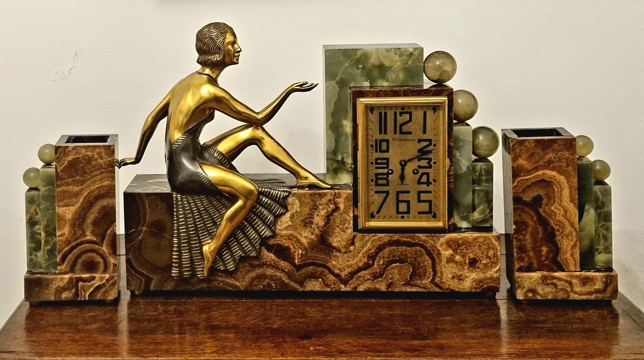 An Art Deco Cubist design figured Marble and Onyx Clock Garniture set . This is an exceptionally rare example of truly impressive proportions , featuring an exquisitely detailed cold painted bronze Art Deco Lady. 

The clock with an onyx face and