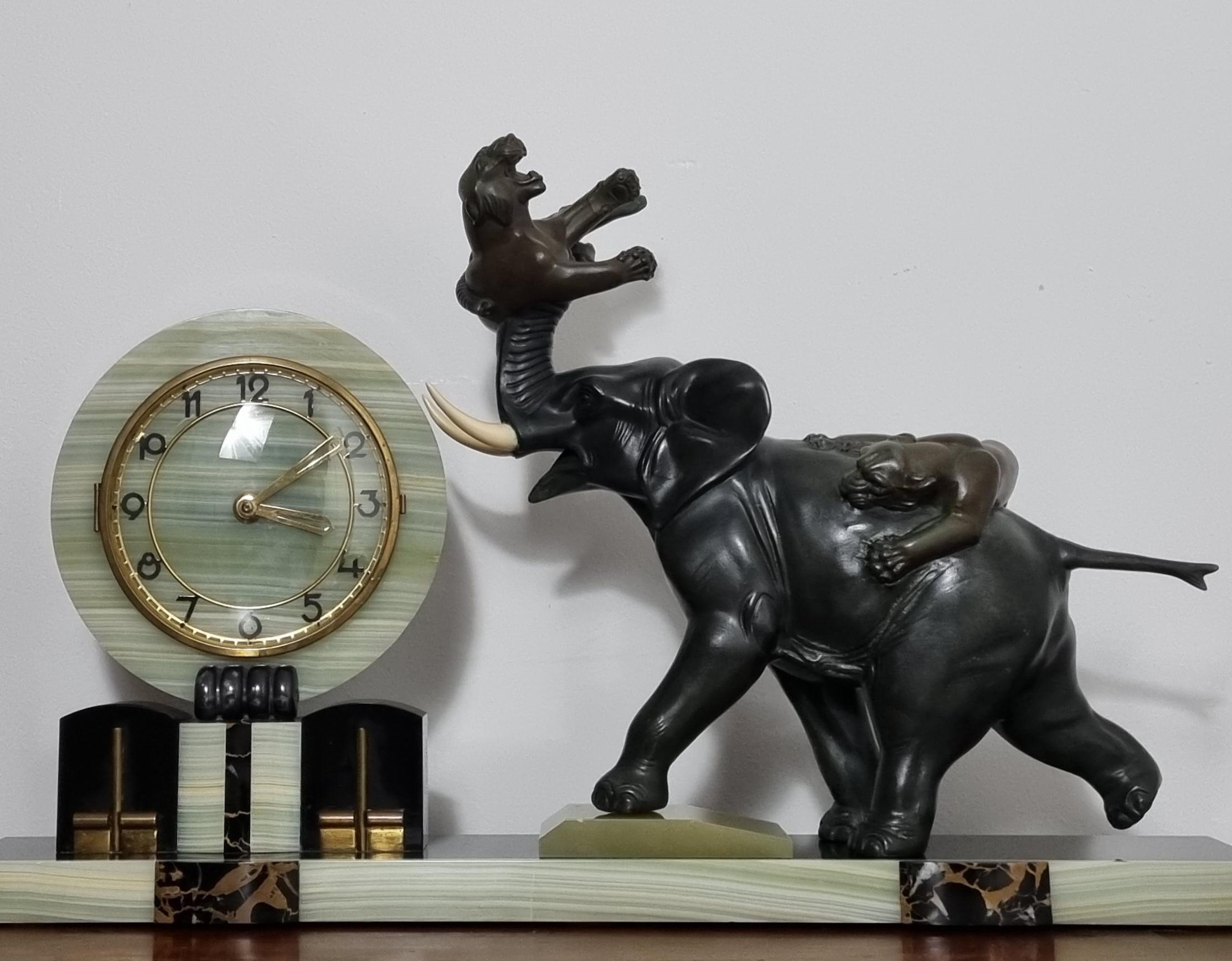 A magnificent Art Deco clock featuring an impressive sculpture in the Japanese Meiji style, depicting two tigers in mid-attack on an elephant. Cast in cold-painted spelter, the scene is intricately detailed, with one tiger clinging to the elephant’s