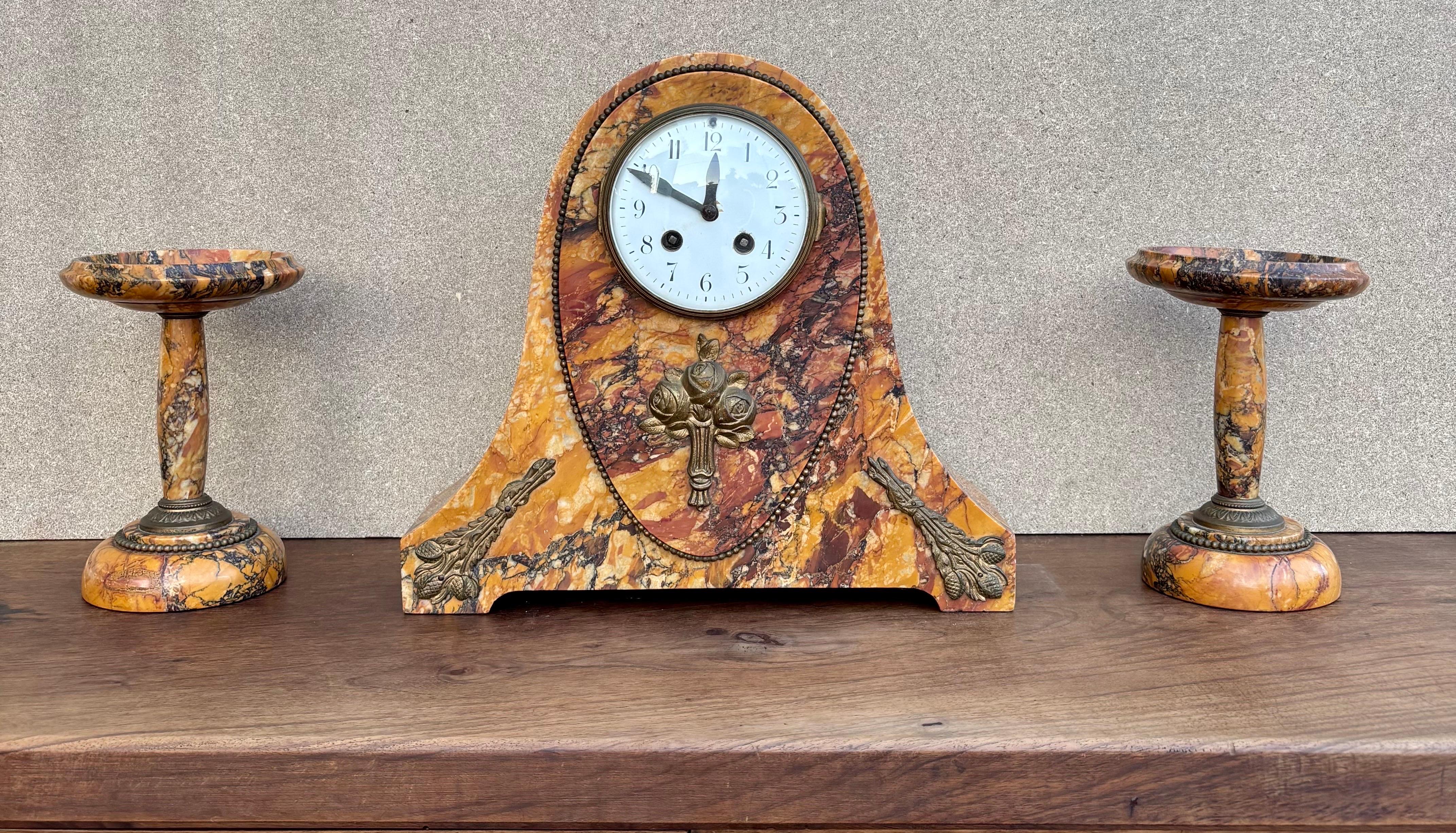 Classic French mantel clock from the early 20th century, manufactured by the prestigious Société Clusienne in Cluses, the birthplace of high-quality watchmaking. Mounted on a veined orange marble base and featuring the same marble inserts enhanced