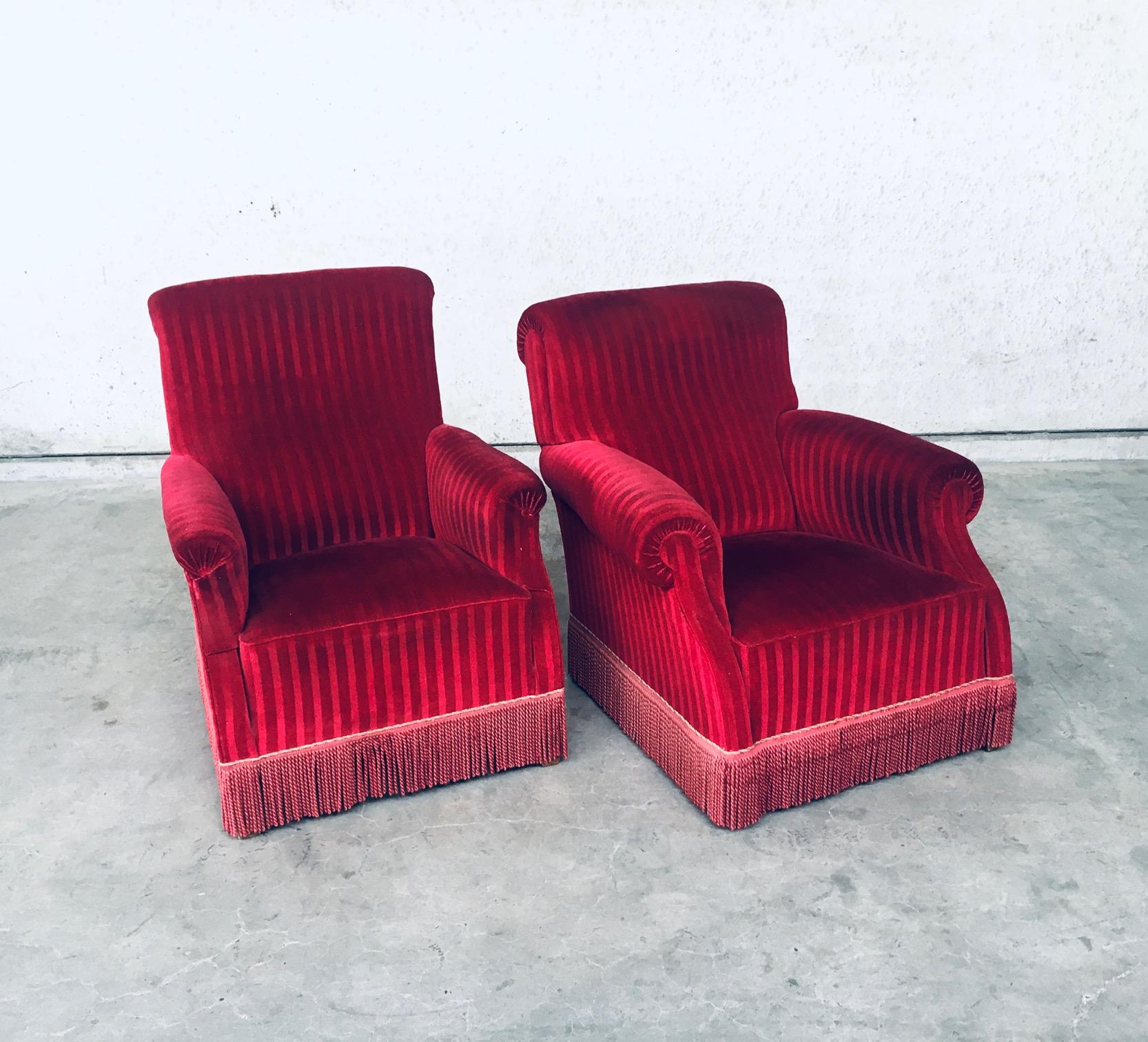 Vintage late Art Deco style club armchair sofa chair set of 2. Made in Belgium, early 1940's. Striped bordeaux red fuschia colored velvet with fringe. A couples chair set, one mens and one womens. One is slightly wider, one is slightly higher.