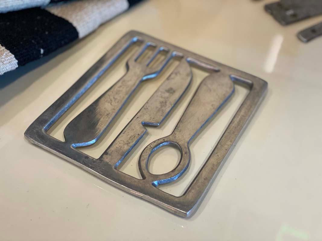 Special Art Deco trivet from the years around 1920. The trivet comes from France and is a real work of art. The grate is not made of usual bars, but made of aluminum, which depicts framed cutlery. So this grate can be more than just a coaster. For