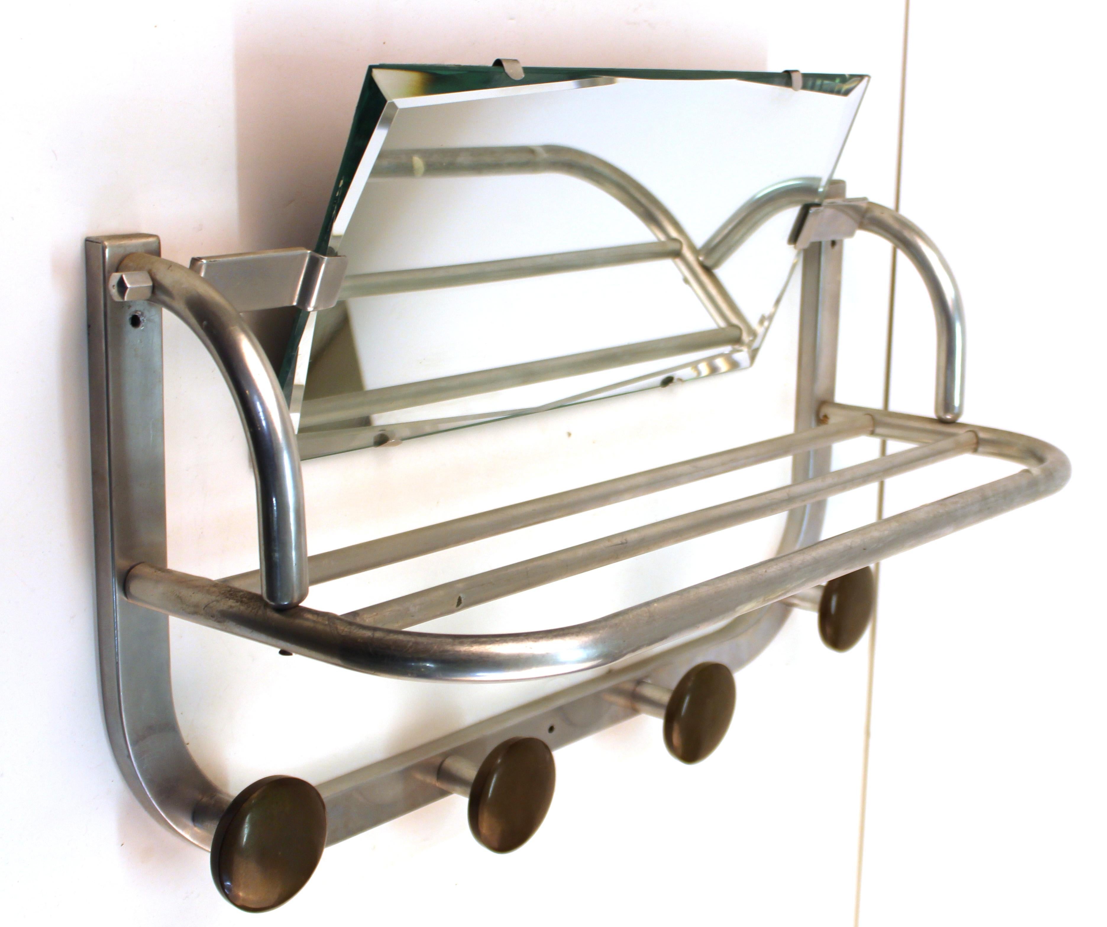 Art Deco coat and hat wall rack in aluminium, with a mirror. The piece has hooks for four coats and ample parking space for hats and gloves on the upper shelf. In great vintage condition with some age-appropriate wear.