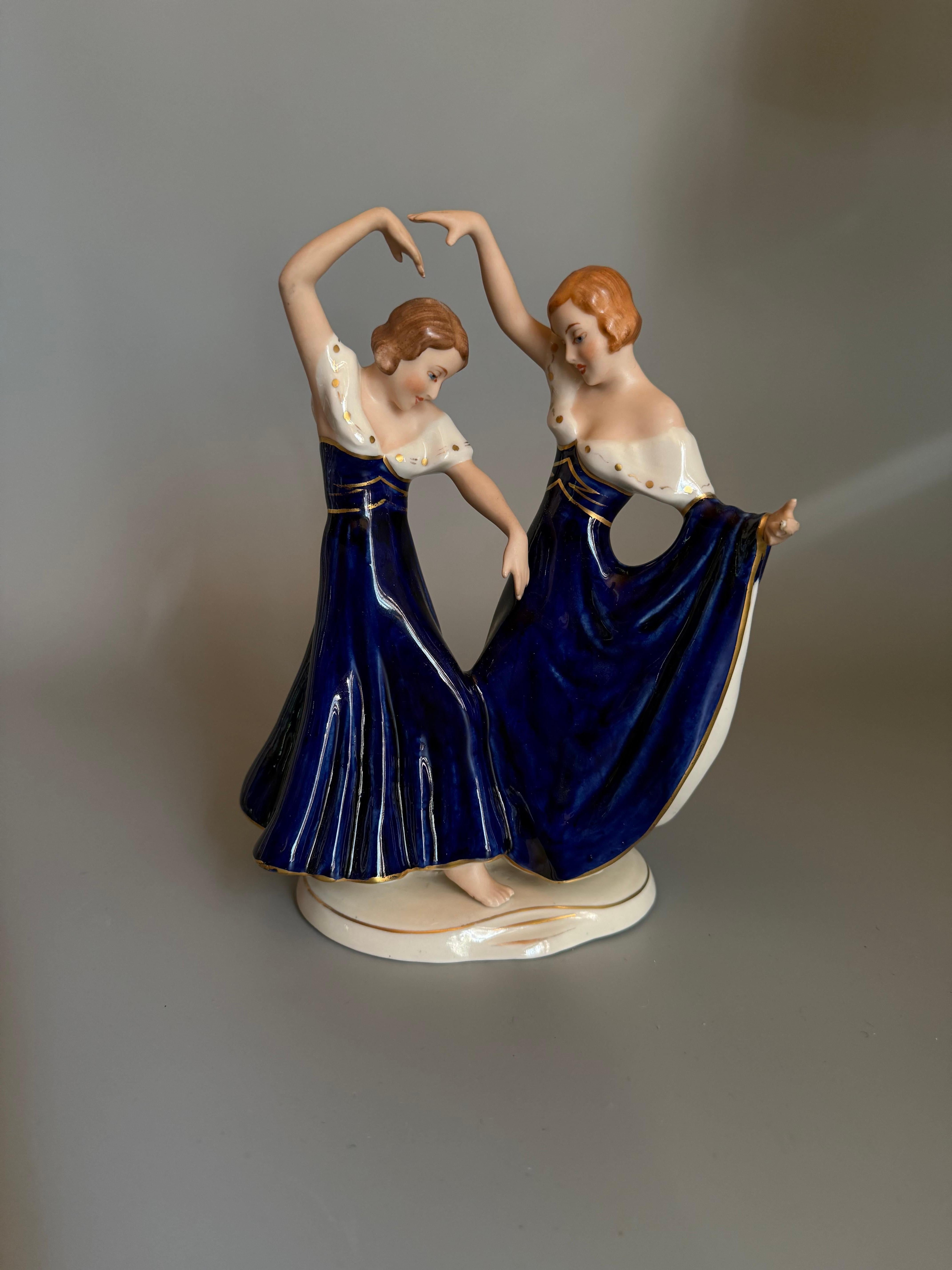 This is a porcelain figurine by Royal Dux, depicting two dancing women, often referred to as 