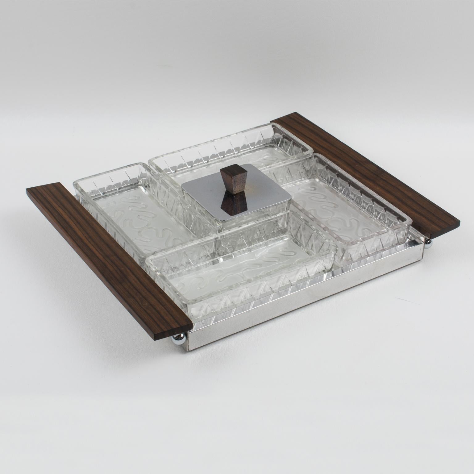 This is an elegant French Art Deco barware serving set for hors d'oeuvres, cocktails, snacks, or appetizers. The square design features a mirrored glass serving tray with a chrome gallery and Macassar wood handles. The five serving dishes for