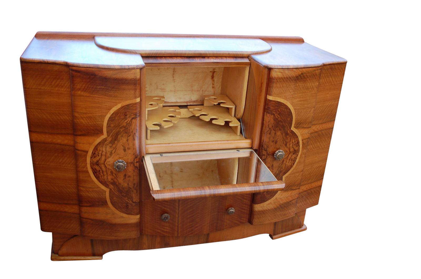 Great shaped piece of Art Deco furniture is both a cocktail cabinet and sideboard.
It has two large side cupboards and two drawers beneath the roll top cocktail cabinet.
Below the cocktail cabinet is a pull out / pull-out mirrored serving