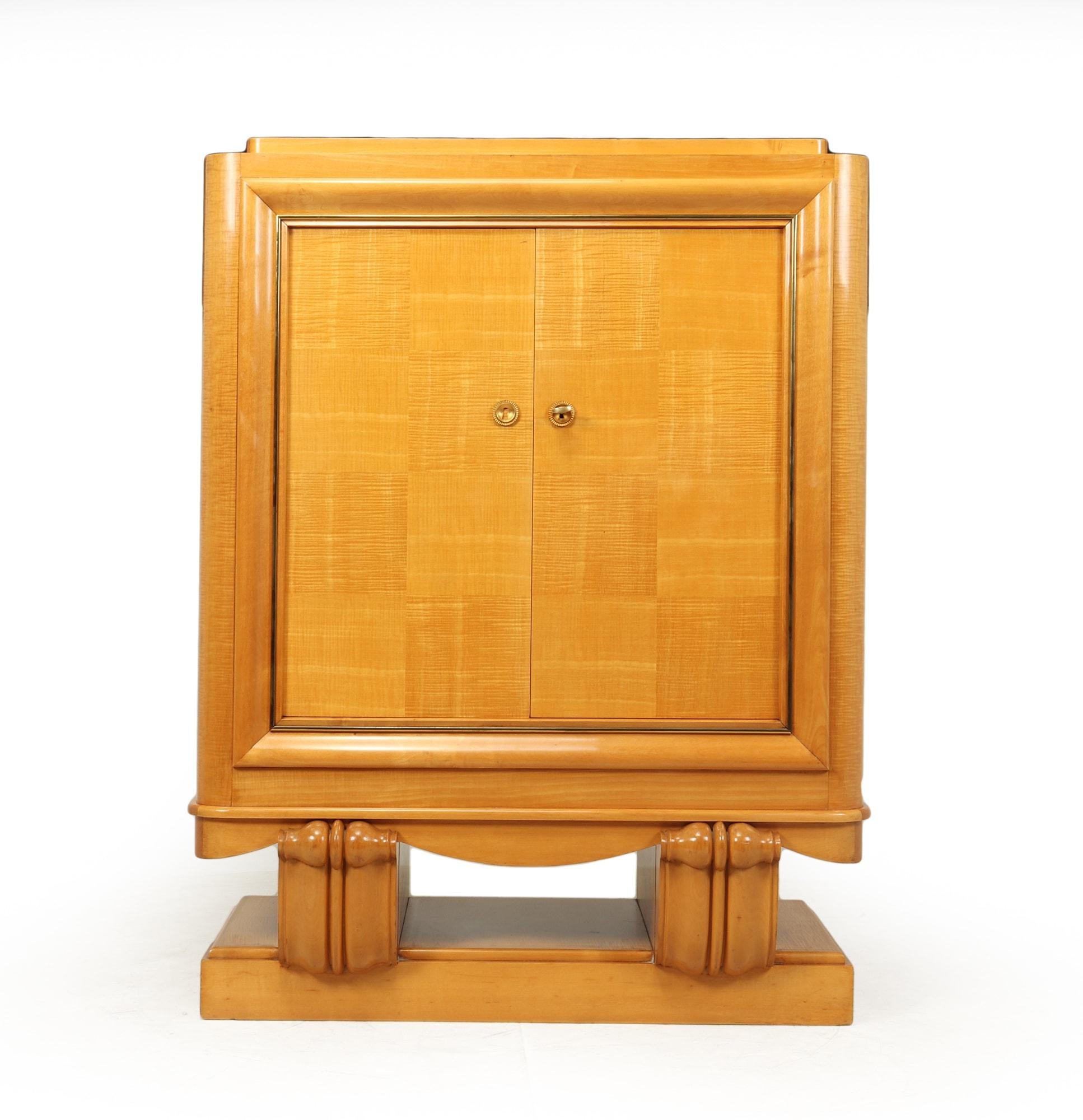 A stunning French Art Deco cocktail drinks cabinet in sycamore with two doors standing on an ornate base, inside has original mirrored slide and raised shelf ( mirror has foxing) the cabinet has been professionally polished by hand and is in