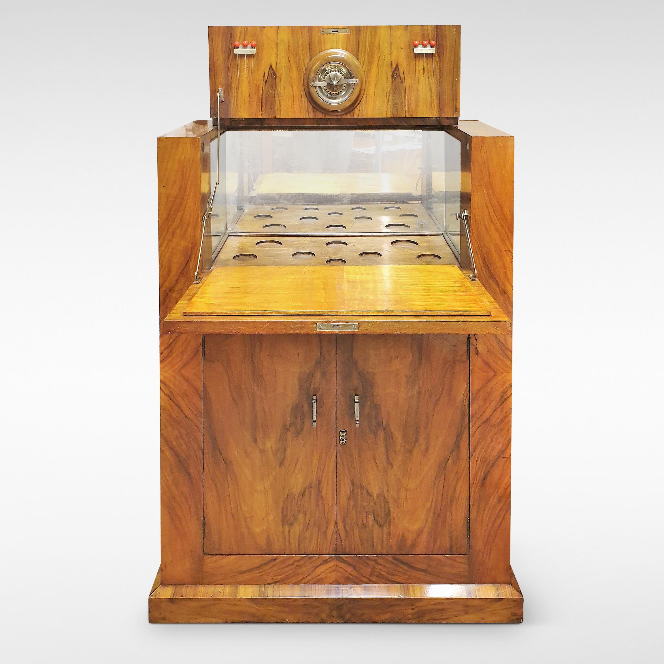A compact Modernist style cocktail cabinet from the Art Deco period in figured walnut veneers with a fitted interior, circa 1935.