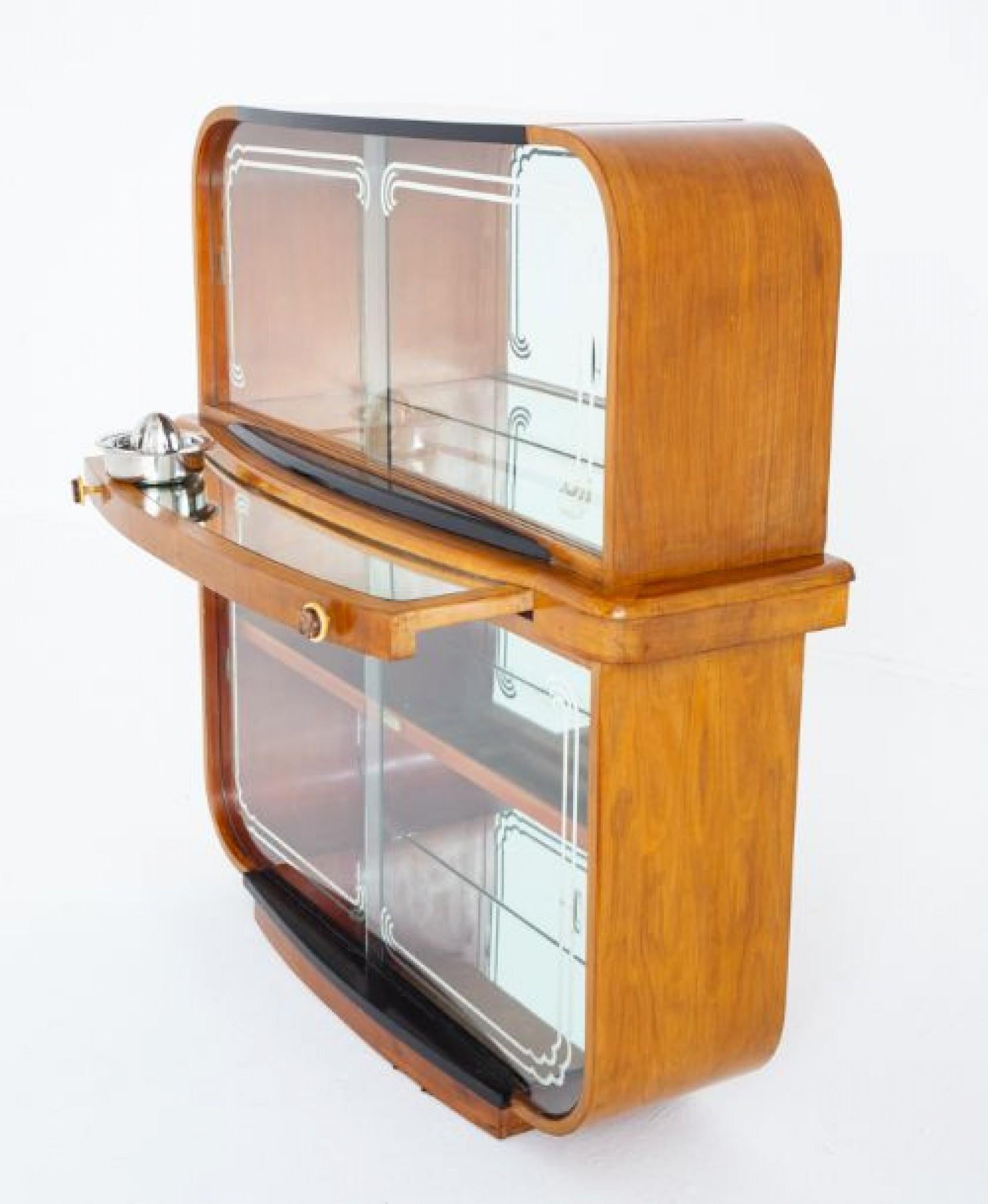 Very stylish art deco walnut cocktail cabinet.
Circa 1930
This cocktail cabinet stands upon a plinth base.
The top and lower section having sliding glass doors and a mirrored interior.
The cabinet features a mirrored pullout slide for mixing ones