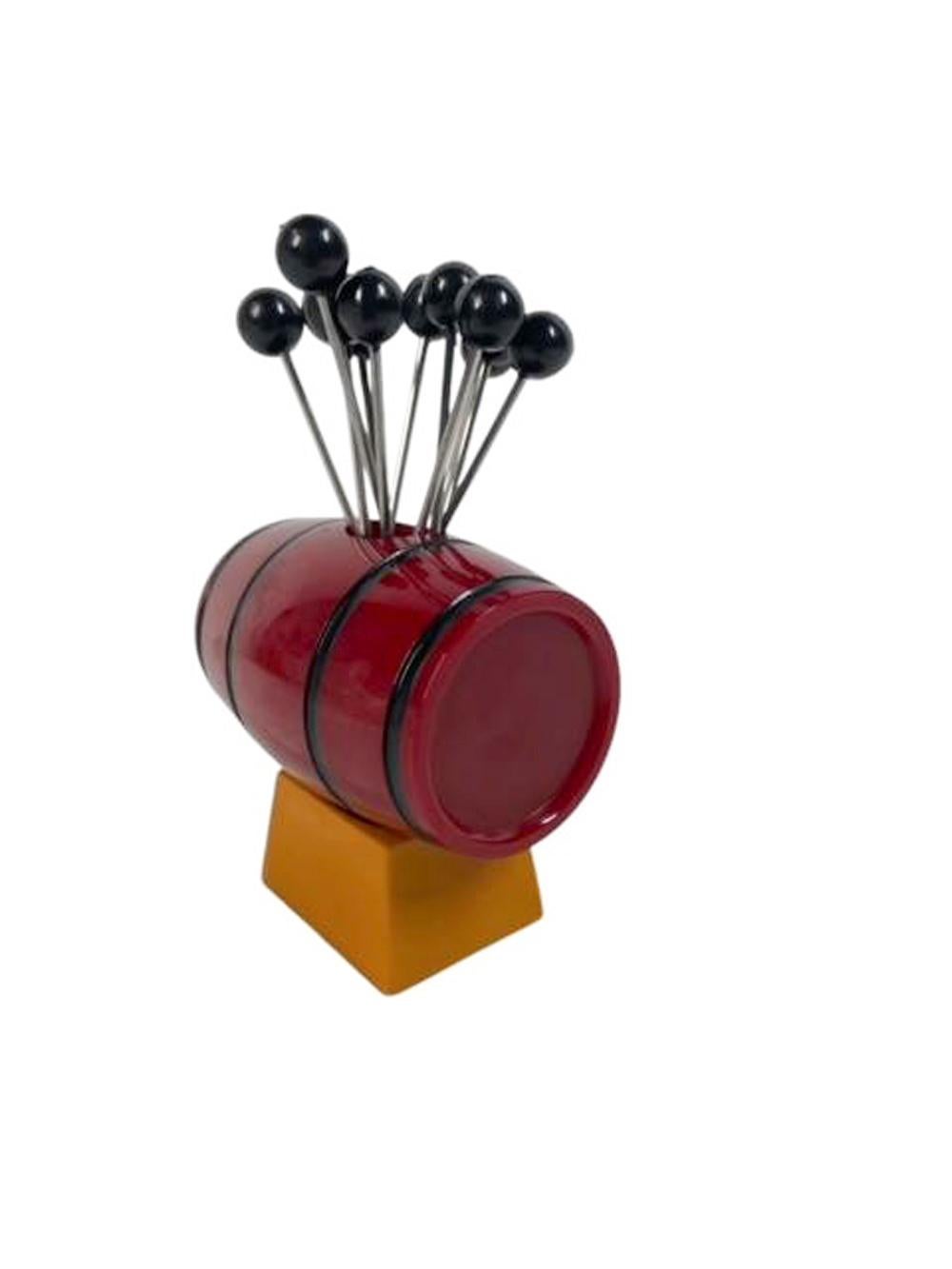 Art Deco Bakelite cocktail pick set. A red Bakelite keg with black bands set on a butterscotch Bakelite base and holding 12 black ball topped steel picks.