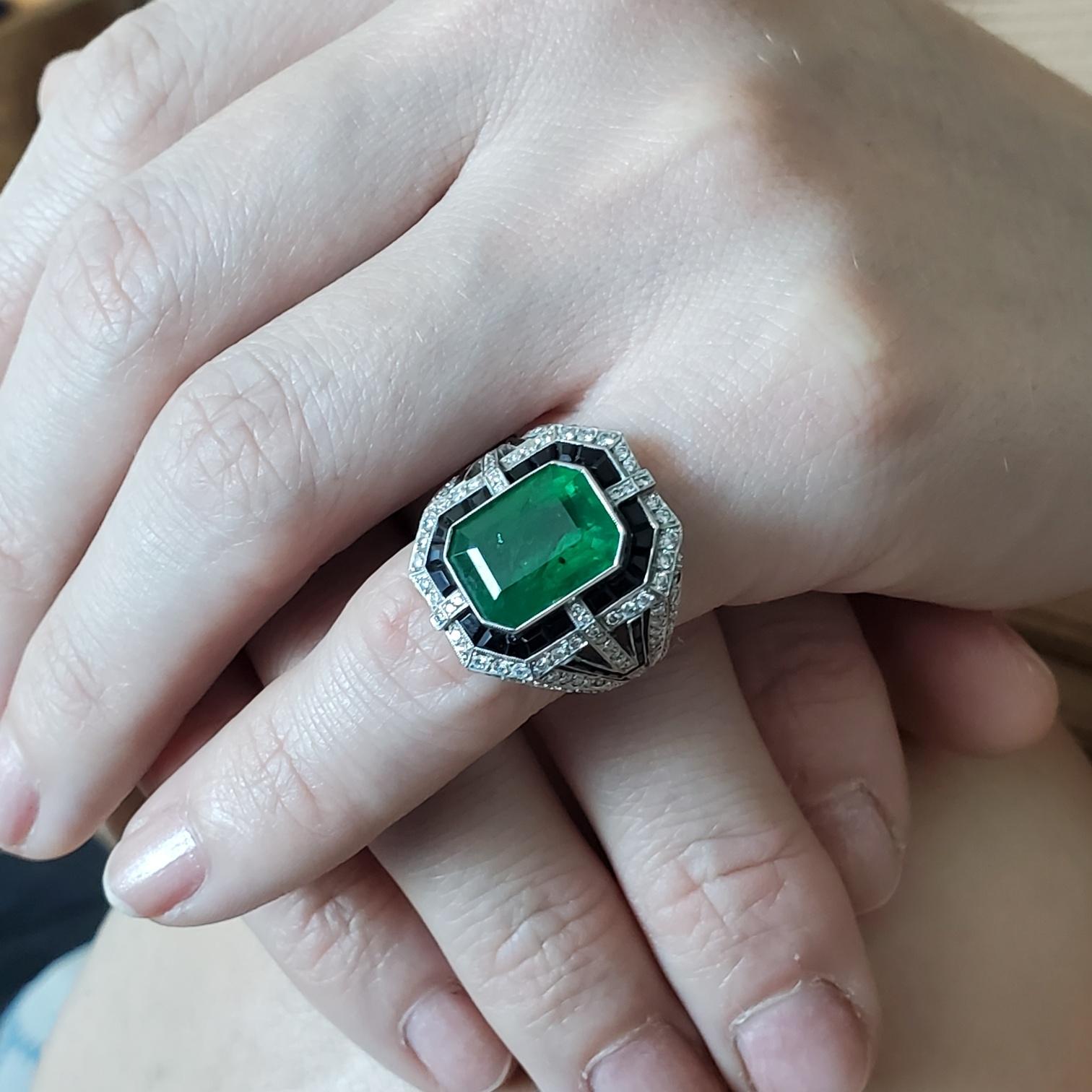 An art deco emerald cocktail ring.

Beautiful cocktail ring, crafted in solid platinum with art deco patterns and embellished with a great selection of natural earth mined gemstones.

Diamonds: Mount in a millegrain setting, with 104 round European