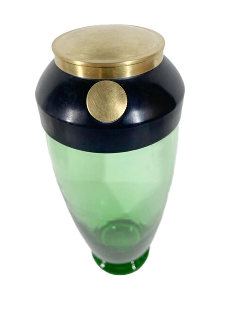 Art Deco, emerald green glass footed cocktail shaker with a black enameled steel lid having a brass cover and screw-on spout cap.