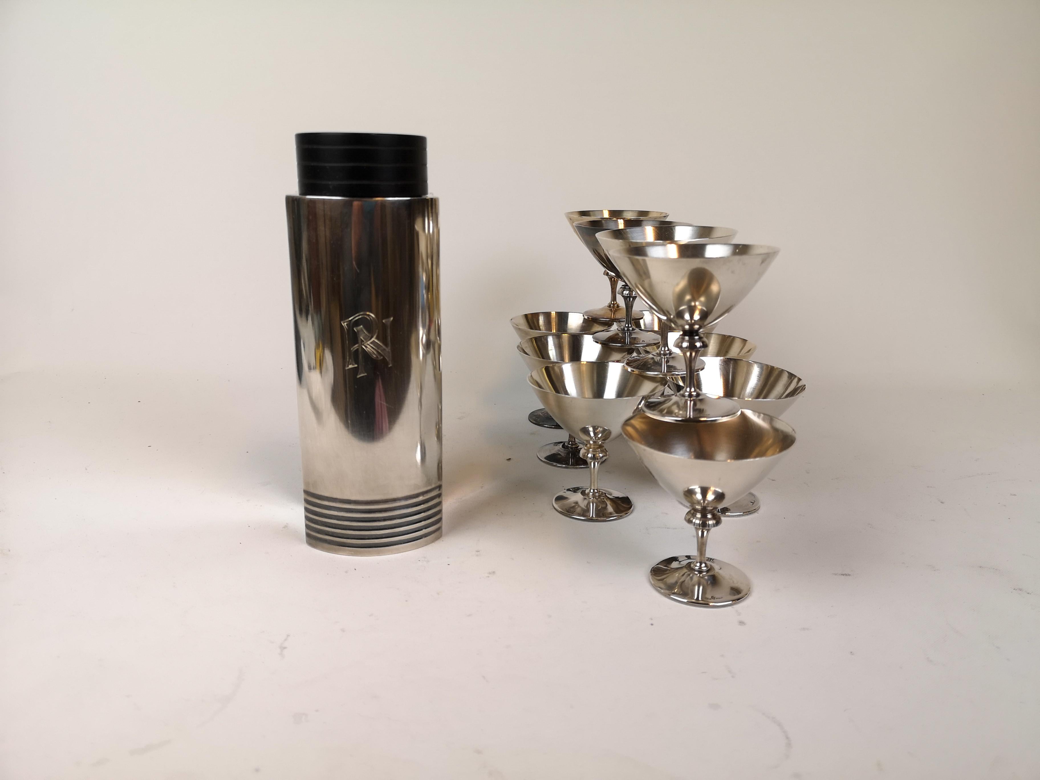 Wonderful, silver-plated Art Deco cocktail shaker and twelve martini glasses. Designed by Folke Arström in Sweden 1936 and produced for GAB. Each piece stamped. The shaker with the engraves RN. Polished or not these items are a great edition to any