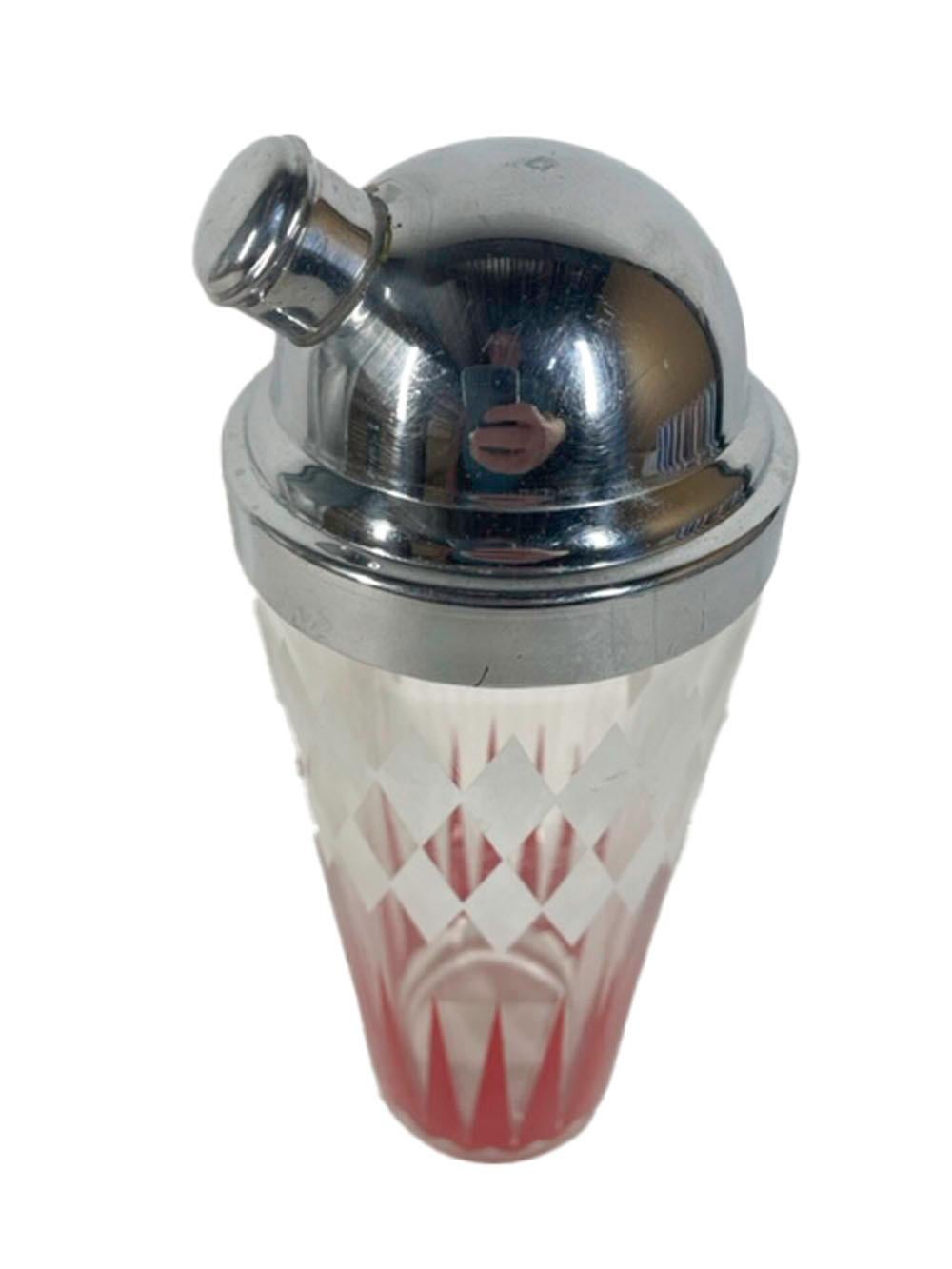 Art Deco cocktail shaker in clear glass with a domed chrome lid with side pour spout and integral strainer. The clear glass body decorated with a double row of white enamel diamonds above elongated red enamel arrows.