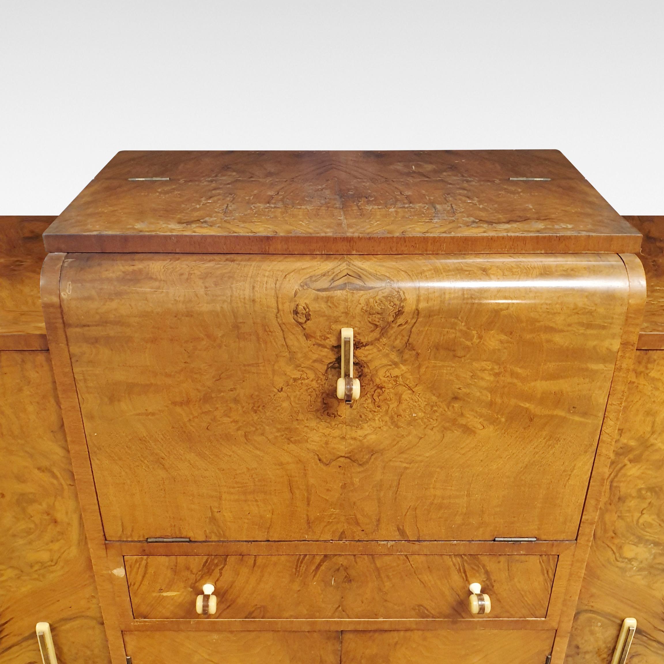 With all the hallmarks of Epstein the first tier English Art Deco furniture makers, this cocktail sideboard in attractive figured walnut veneers has a drop down front opening to reveal a fully fitted interior, circa 1935-1955

The price includes